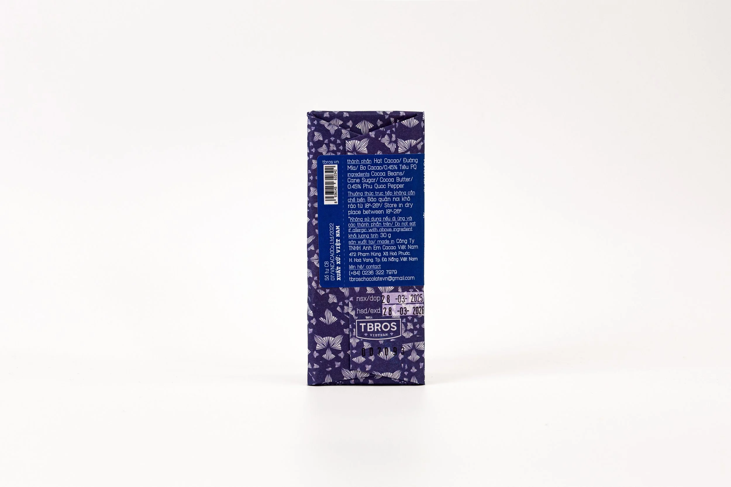A rectangular purple package with white butterfly patterns and blue labels, standing upright on a white surface.