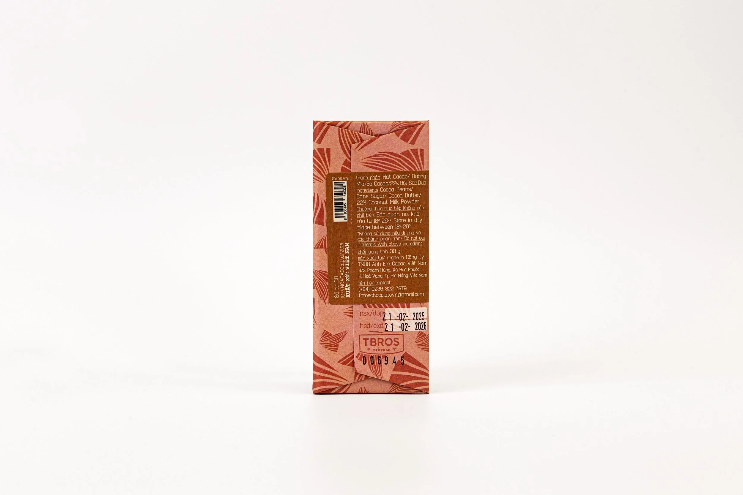 Back of a pink and brown packaged product with text in Vietnamese and a barcode, standing upright on a plain white background.