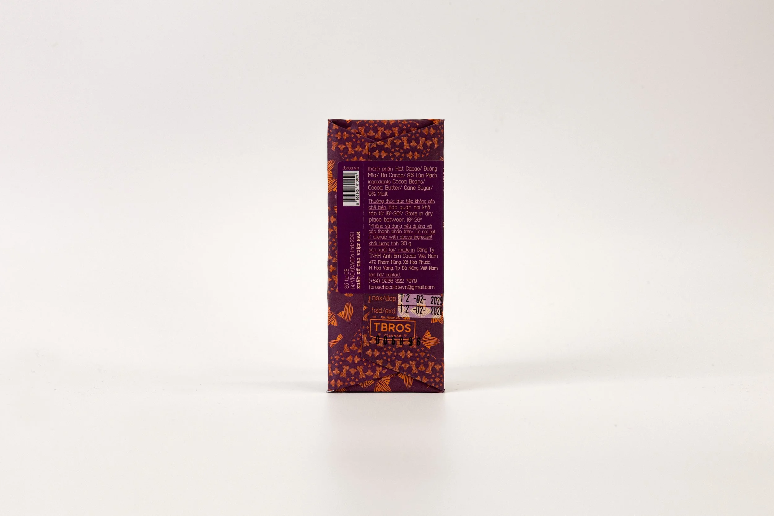 A rectangular chocolate packaging box with a purple and orange design, showing ingredients and product information.