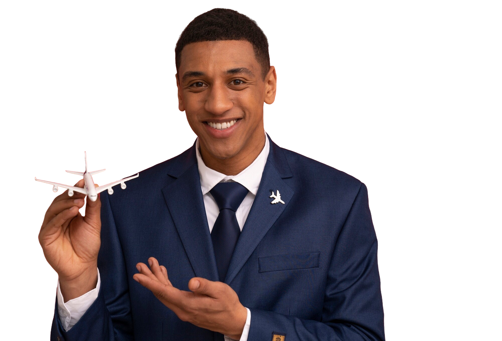 A smiling man in a navy suit and tie holding a small model airplane.