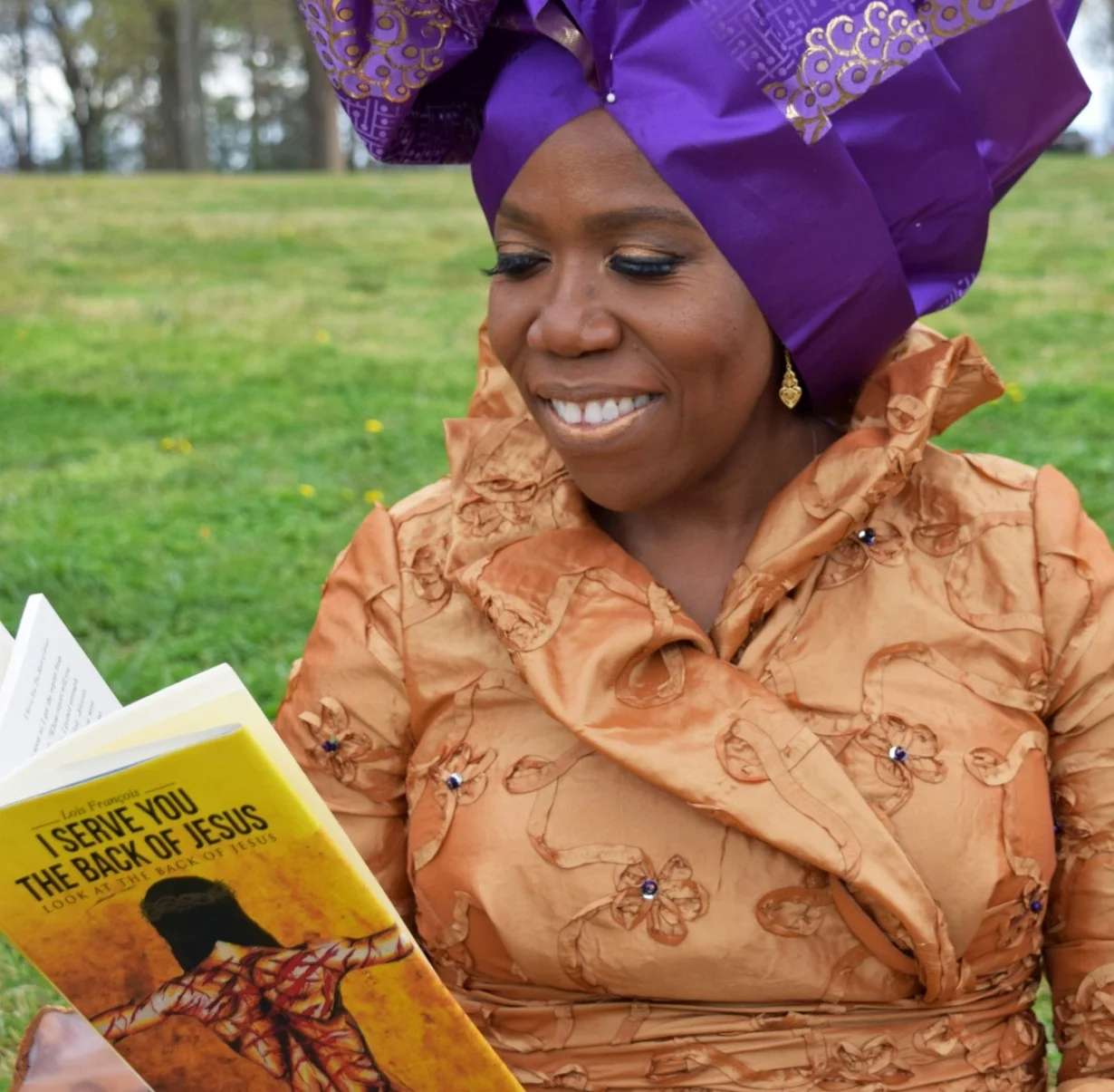 She’s an author too! Mrs. Francois enjoying a copy of her autobiography, I Serve You The Back of Jesus.