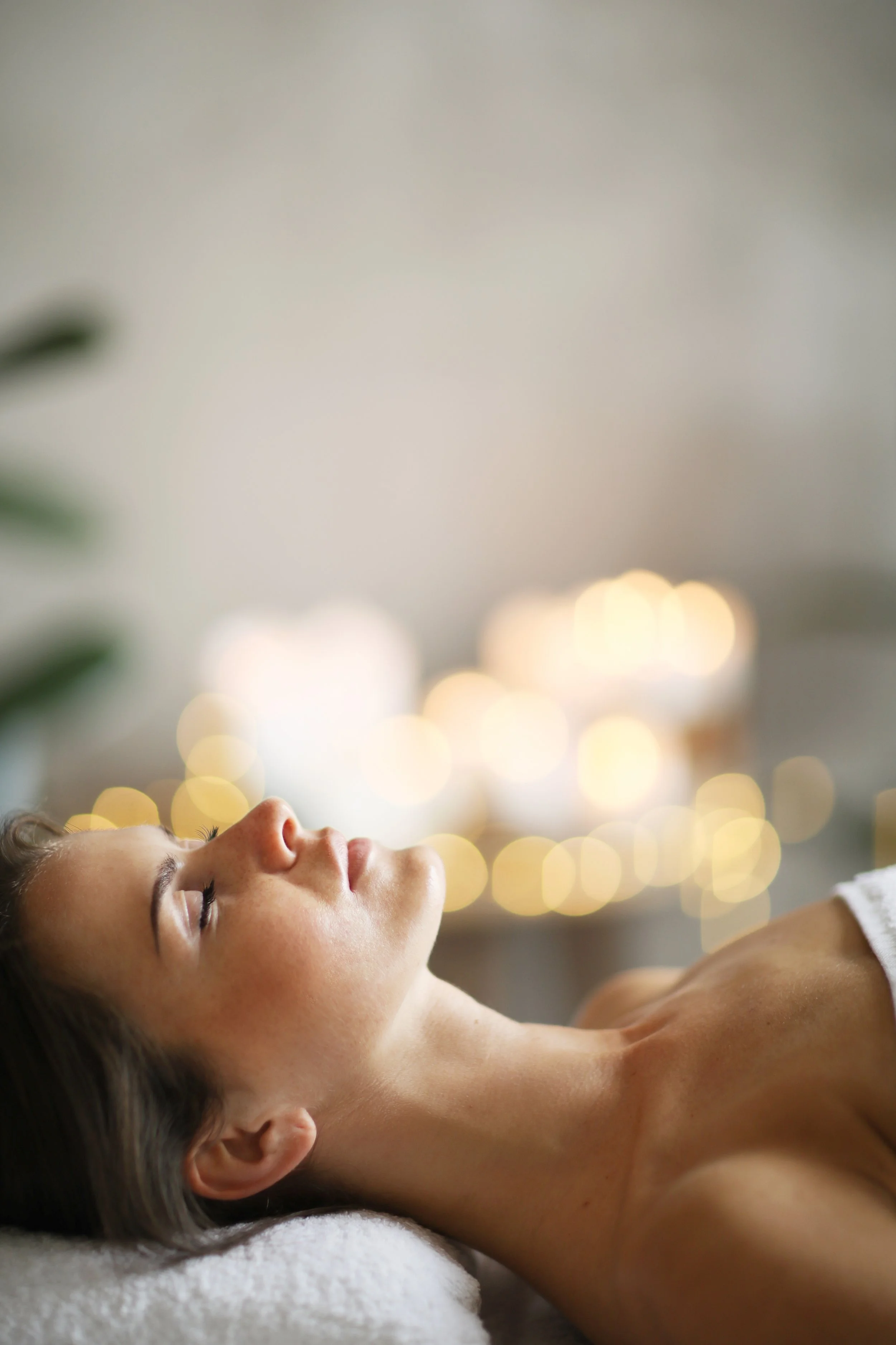 A woman receiving a relaxing massage in a spa with soft, warm lighting.
