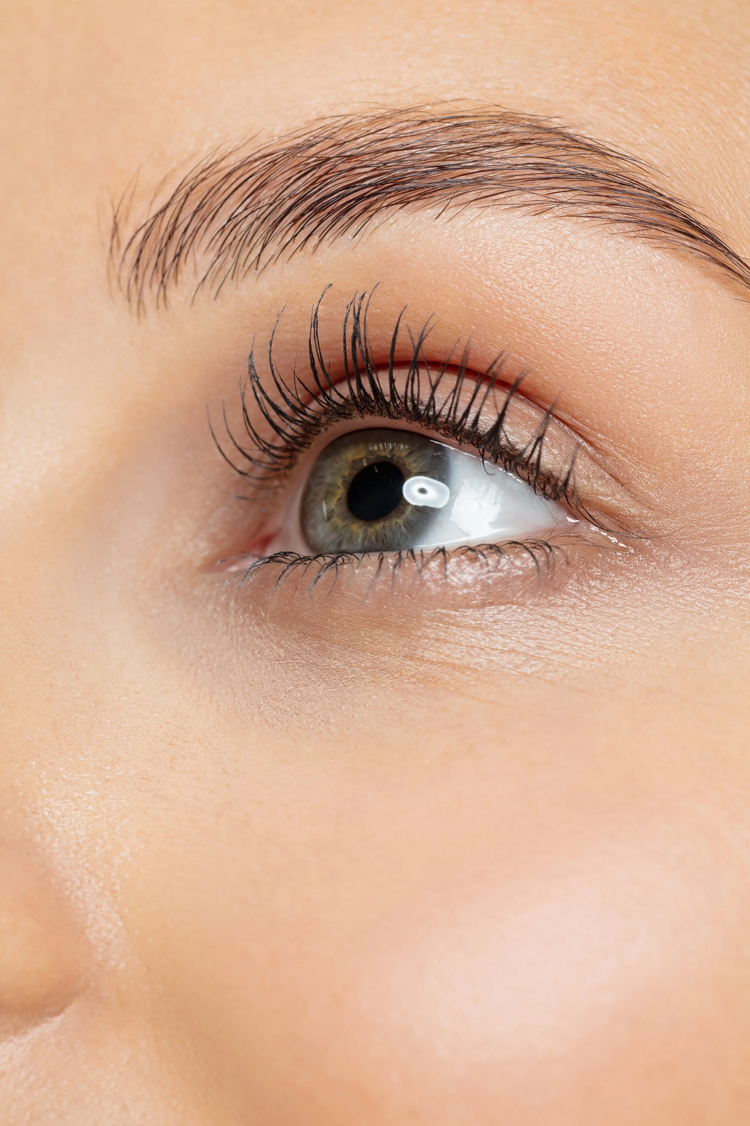 Close-up of a person's right eye with visible eyelashes, eyebrow, and skin texture.