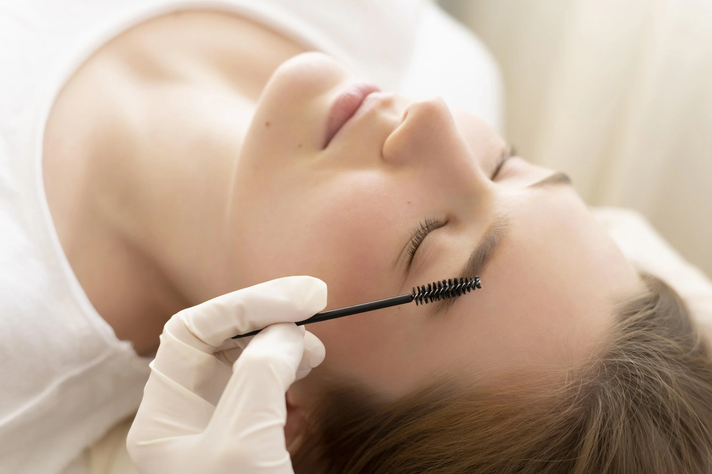 A woman getting her brows groomed at a beauty salon.