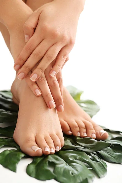 Person massaging their ankle and foot, with green leaves underneath on a white background.