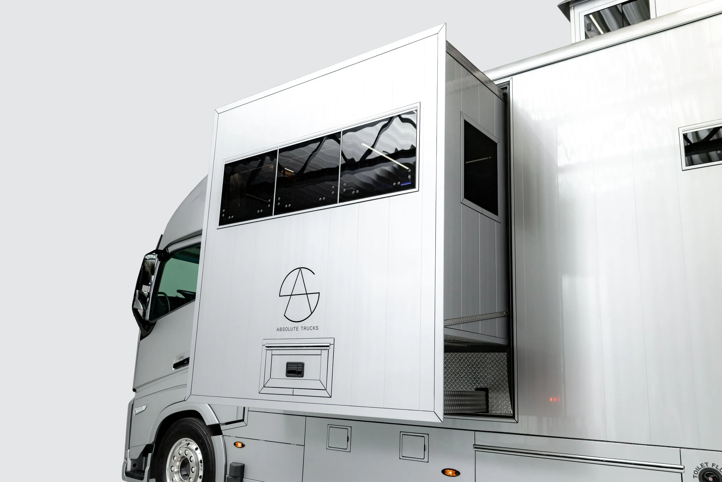 Silver mobile pet grooming trailer with multiple ramps and windows