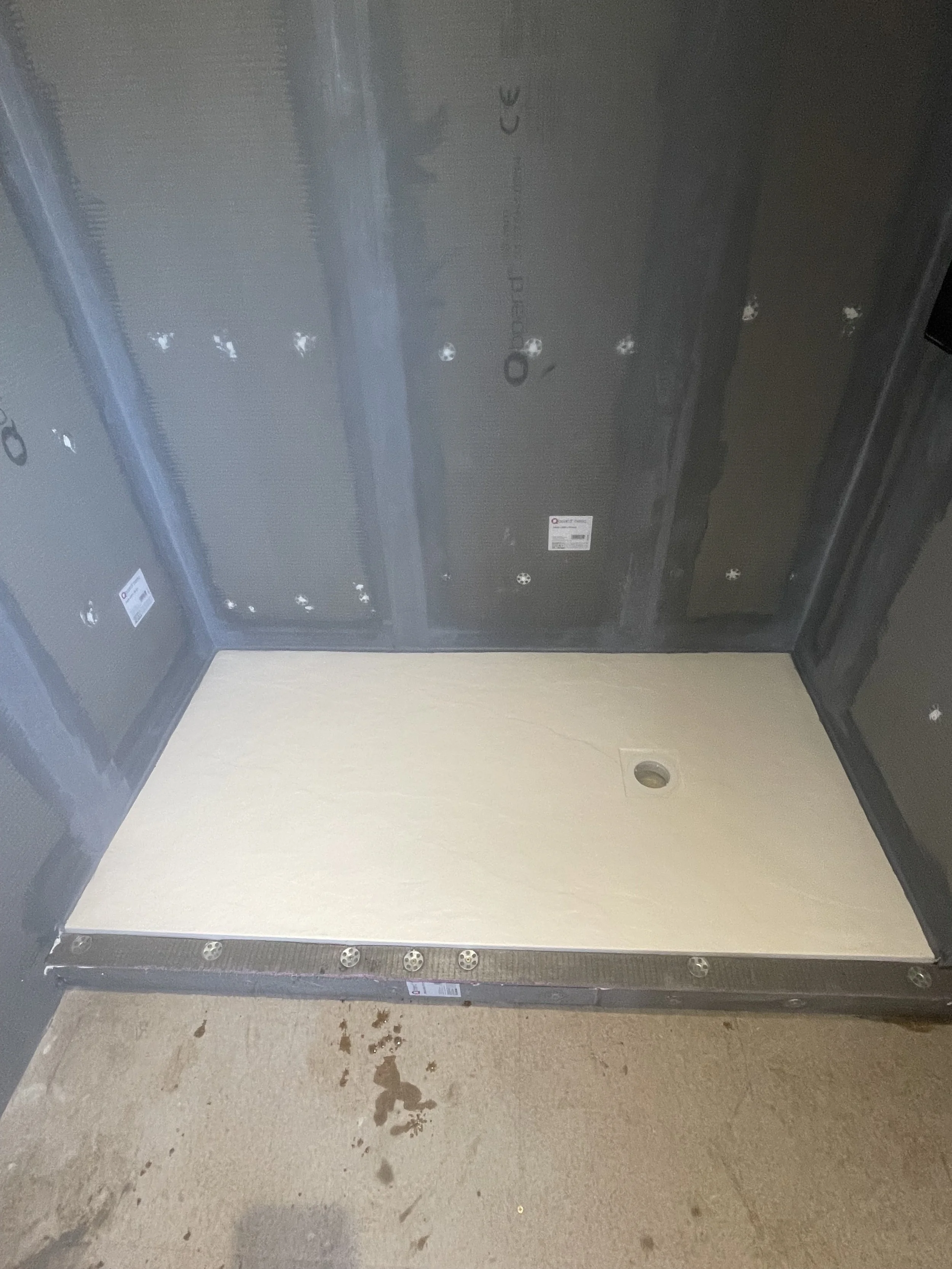 Luxury bathroom renovation under construction with shower tray installed and waterproof preparation completed.