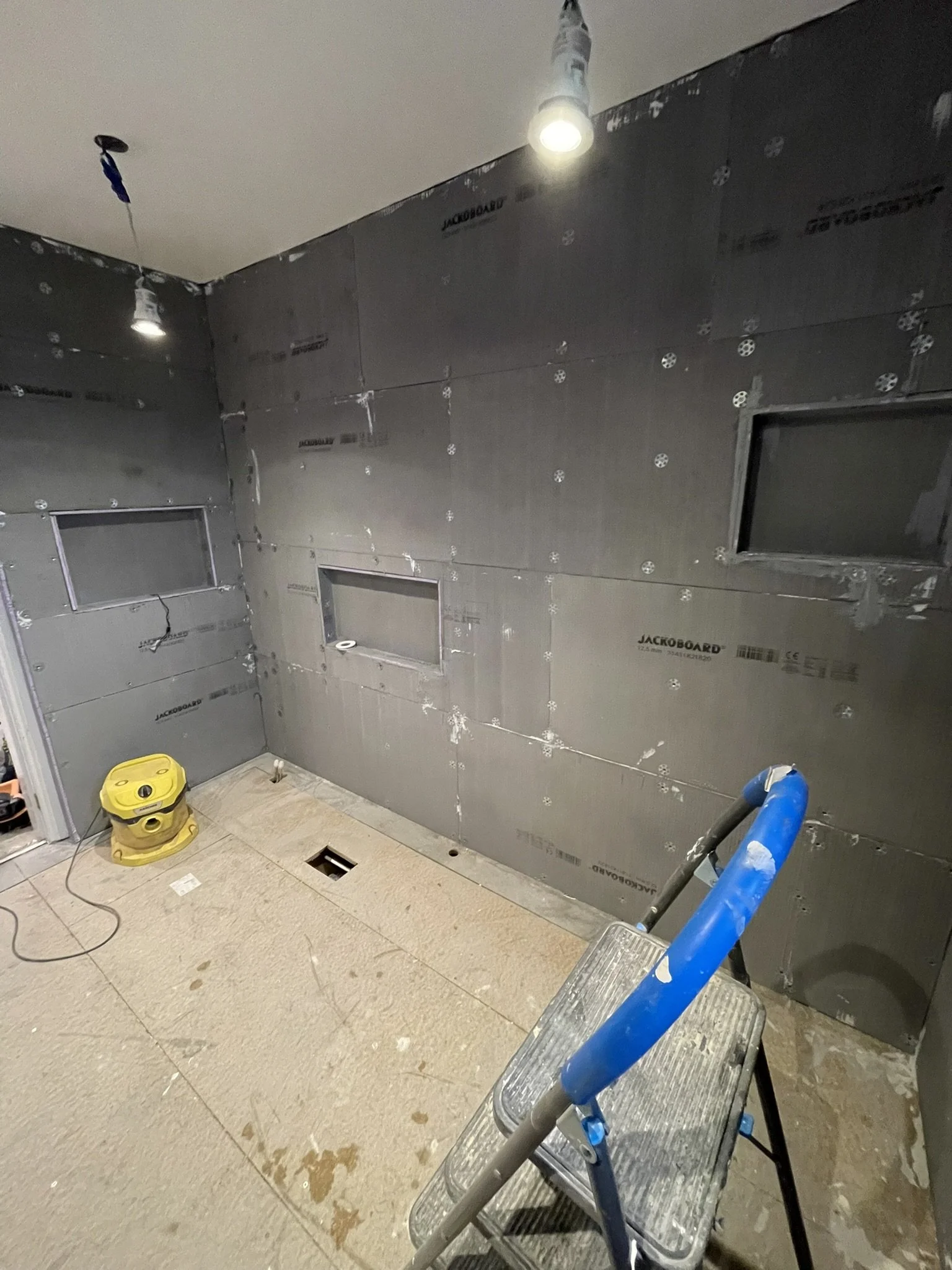 Bathroom renovation in progress with waterproof wall preparation before tiling and installation.