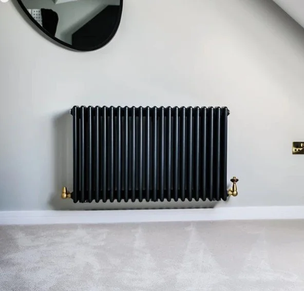 Contemporary anthracite designer radiator professionally installed as part of a premium home renovation.