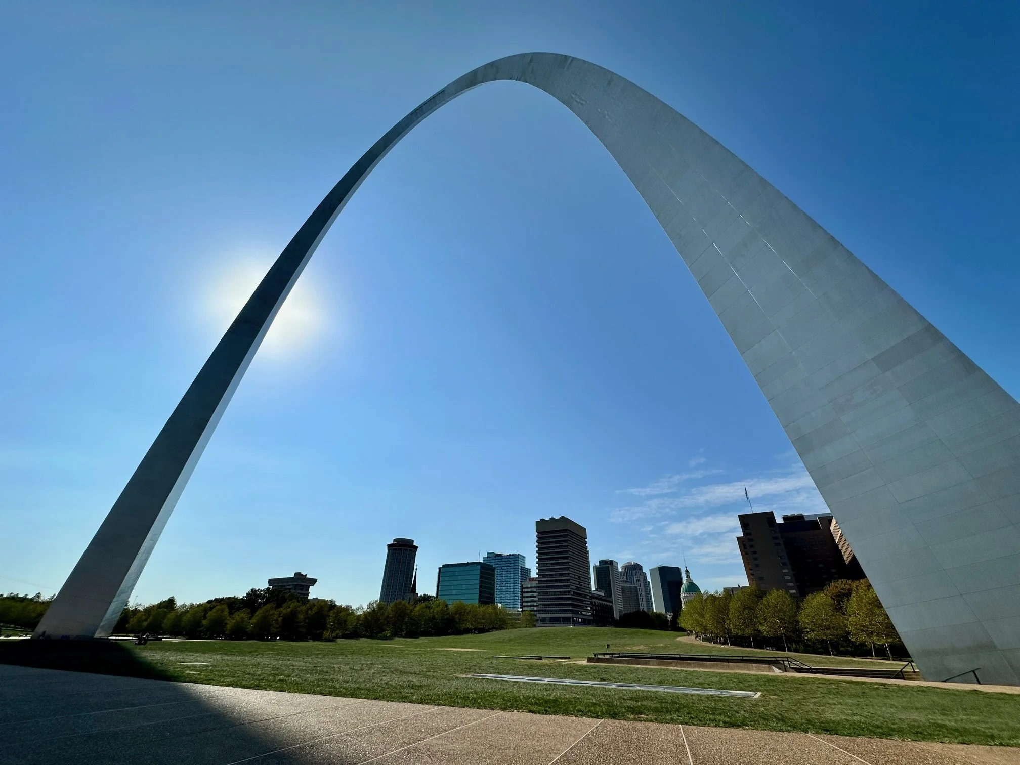 Gateway Arch in St. Louis with downtown city buildings in the background on a clear day