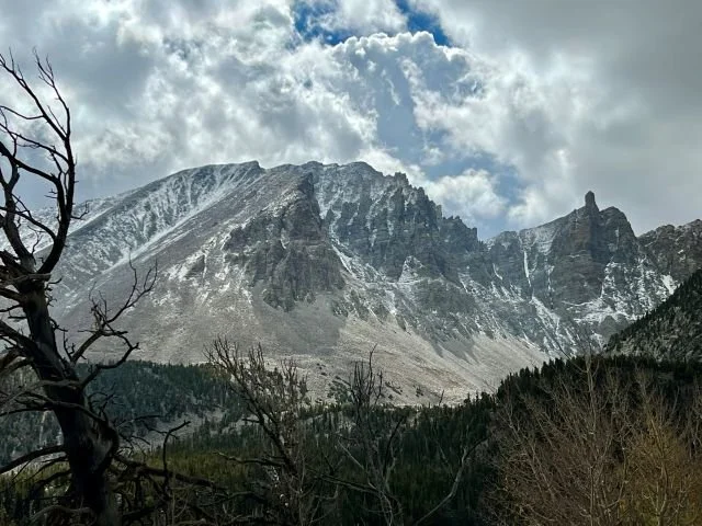 Electric vehicle road trip stop at Mount Wheeler in Great Basin National Park, Nevada, with scenic mountain peaks and clear blue sky in the background.