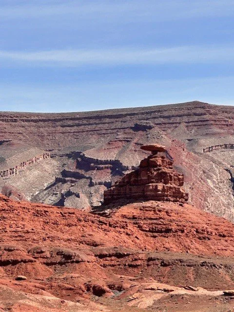 Mexican Hat Rock rises above the desert near Monument Valley, Utah, its sombrero-shaped silhouette standing out against the rugged Southwest landscape.