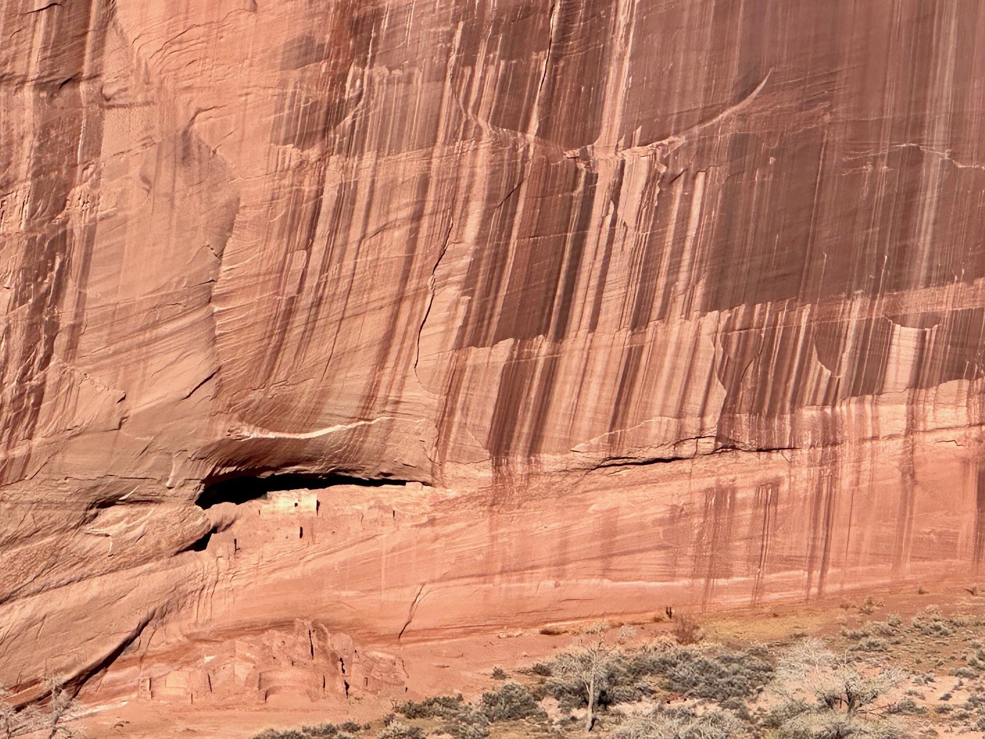View from White House Overlook at Canyon de Chelly National Monument, with the ancient White House Ruin tucked beneath towering red sandstone cliffs above the canyon floor.