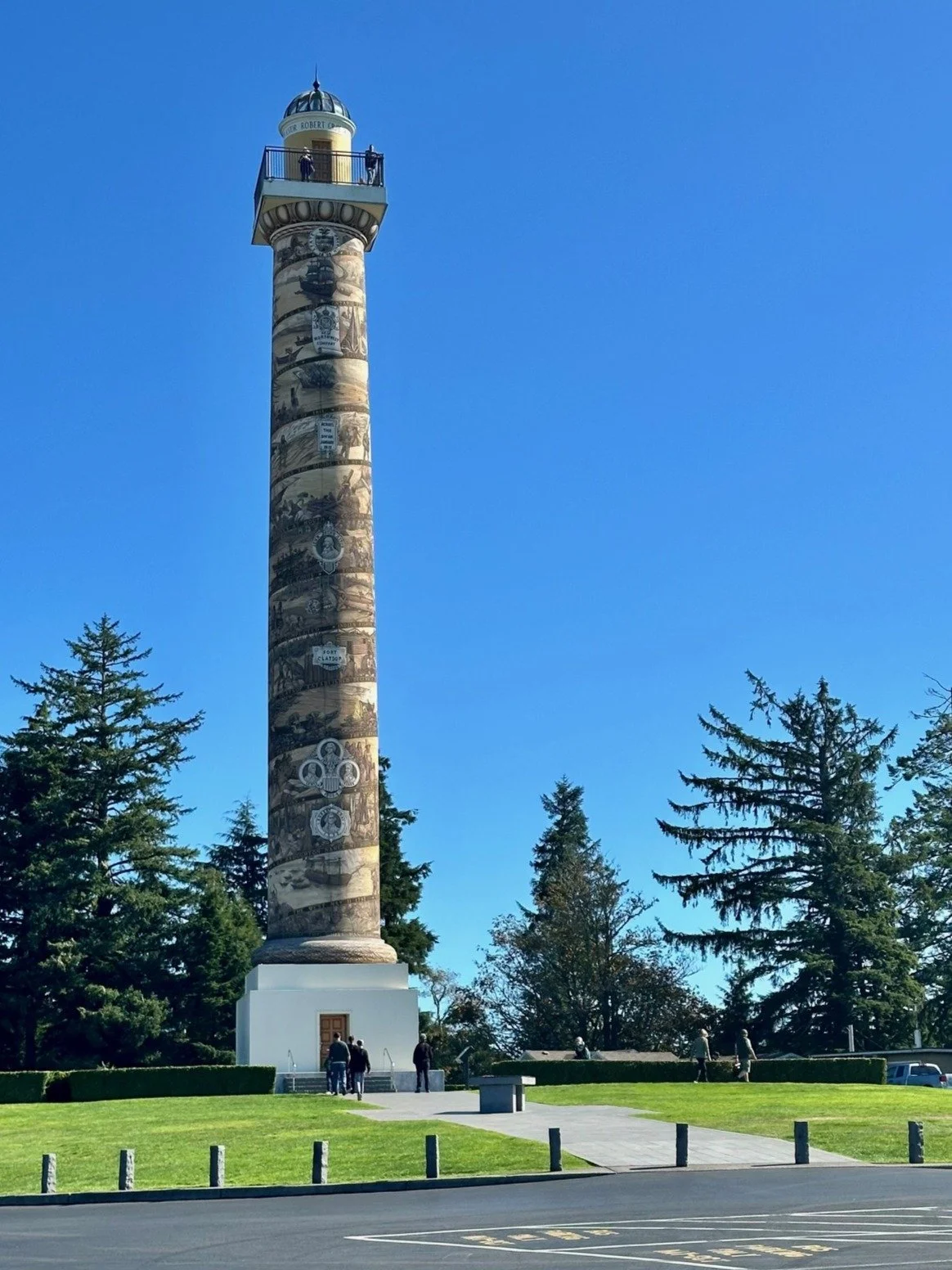 Astoria Column landmark viewed from ground level, surrounded by trees in Astoria, Oregon.