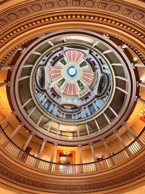 Upward view of the ornate rotunda ceiling inside the historic St. Louis Old Courthouse at Gateway Arch National Park, a Missouri landmark featuring classical architecture and intricate design.