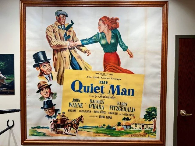 Original movie poster for the 1952 film ‘The Quiet Man,’ featuring illustrated portraits of the lead characters, rural Irish scenery, and classic vintage poster styling.