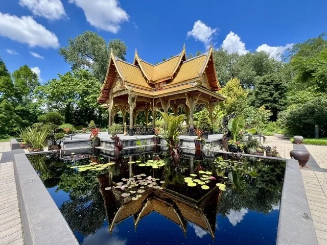 The Royal Thai Pavilion and Garden at Olbrich Botanical Gardens in Madison, Wisconsin, showcasing handcrafted Thai architecture, gold-leaf accents, lush greenery, and tranquil water features.