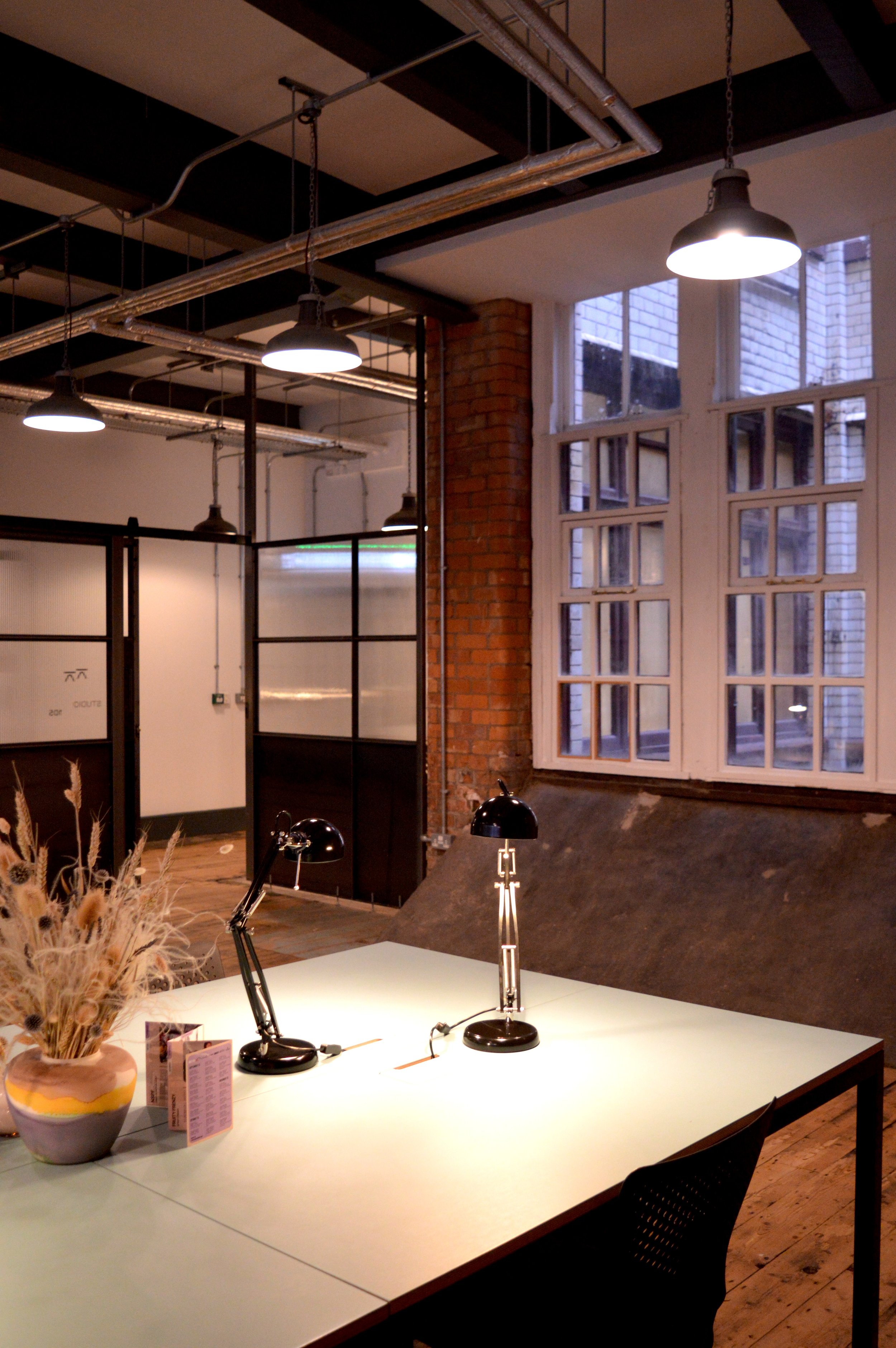 Studio space in a red brick building, with a large window overlooking Manchester.