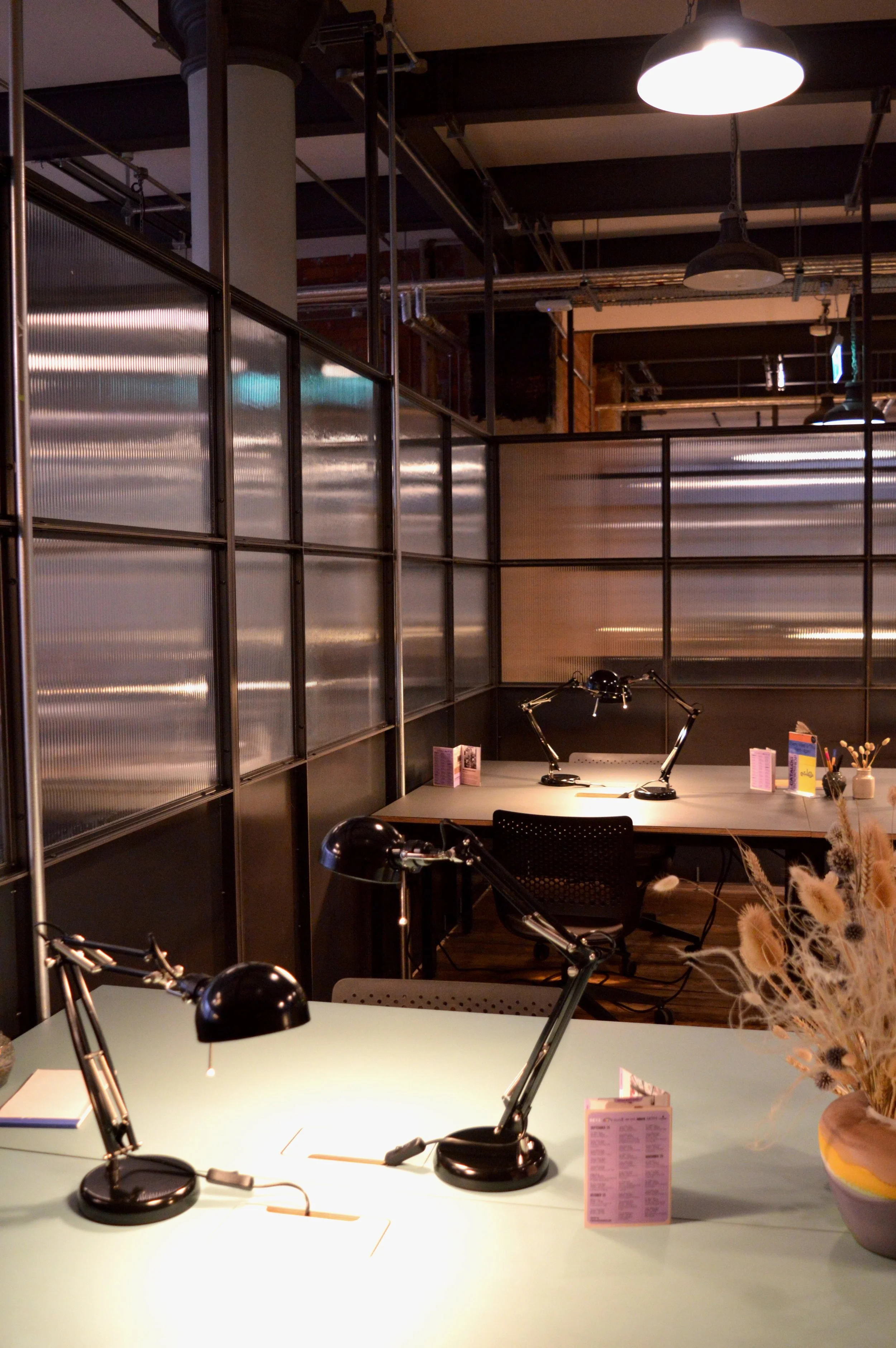 Two desks in a brightly lit partitioned studio.