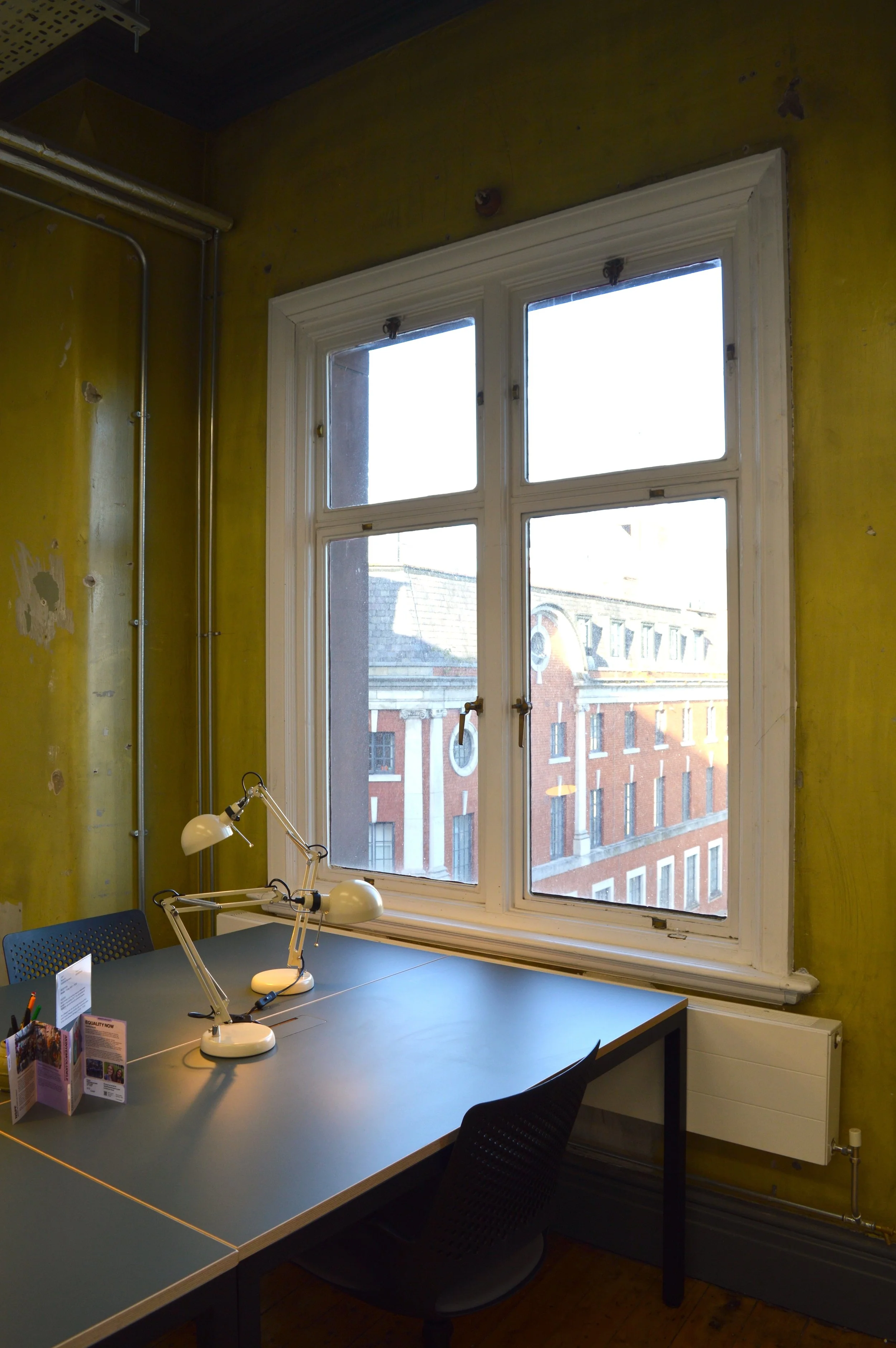 A view of Manchester's red brick architecture out the window of a private office space.