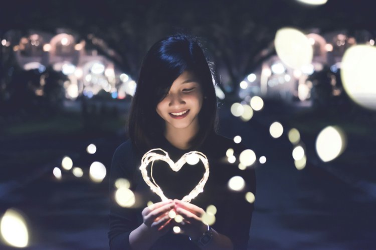 Girl holding a heart of string lights