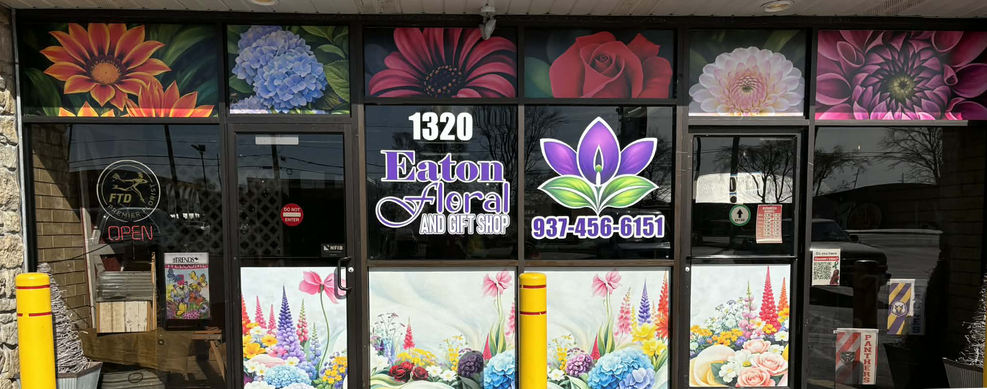 The storefront of Eaton Floral and Gift Shop with colorful floral artwork on the window, an 