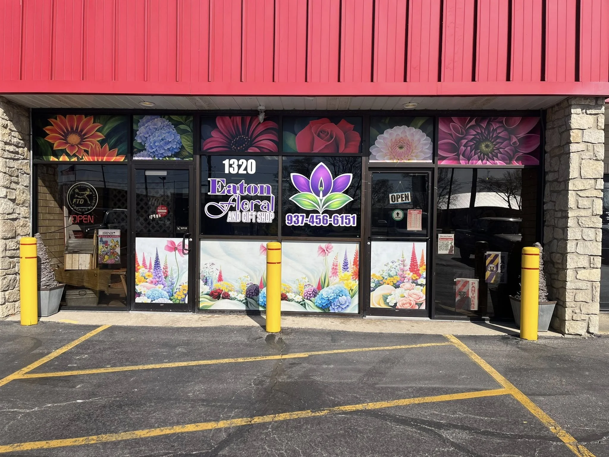 The storefront of Eaton Floral and Gift Shop with colorful floral artwork on the window, an 