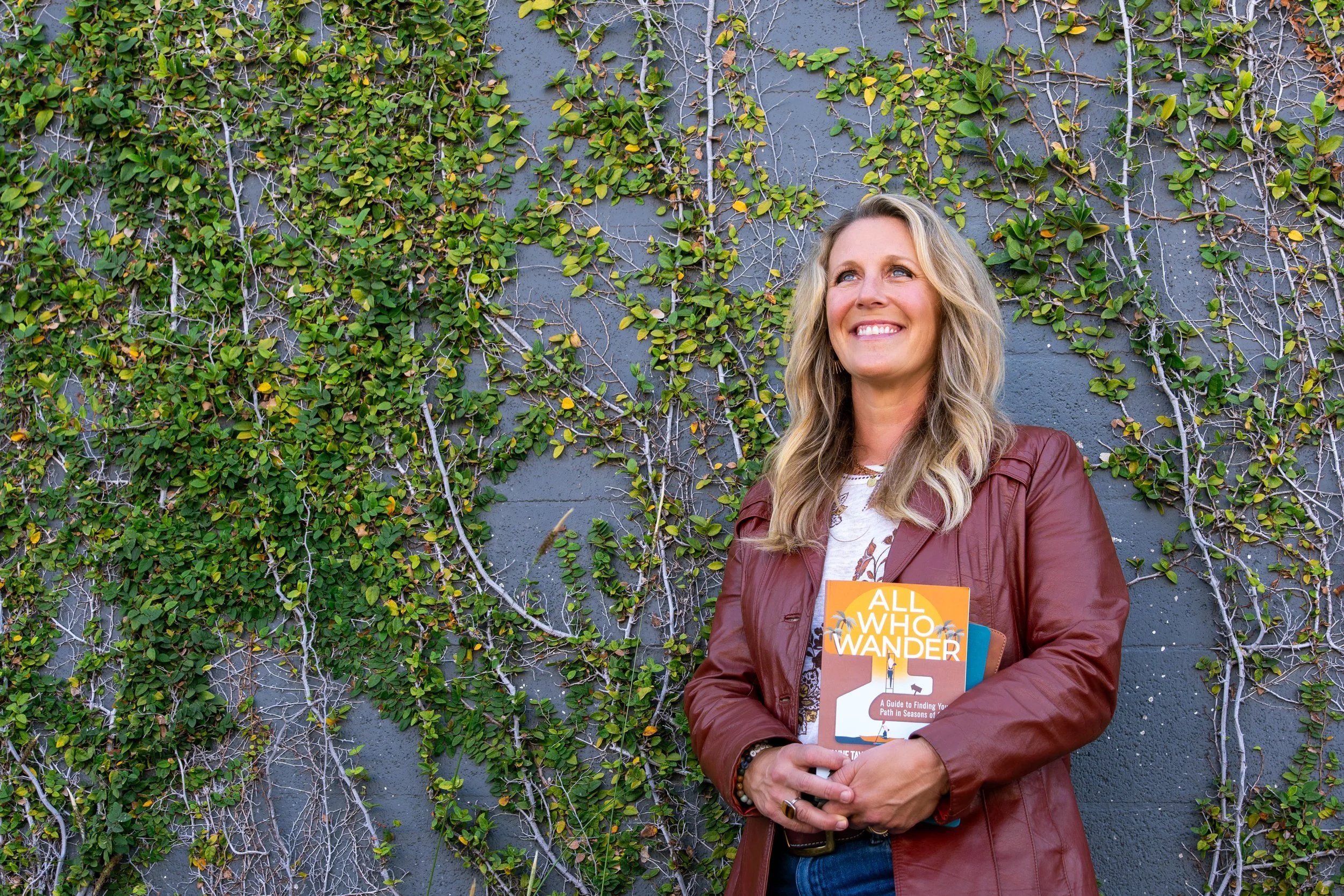 Anne Taylor Hartzell holding her book All Who Wander