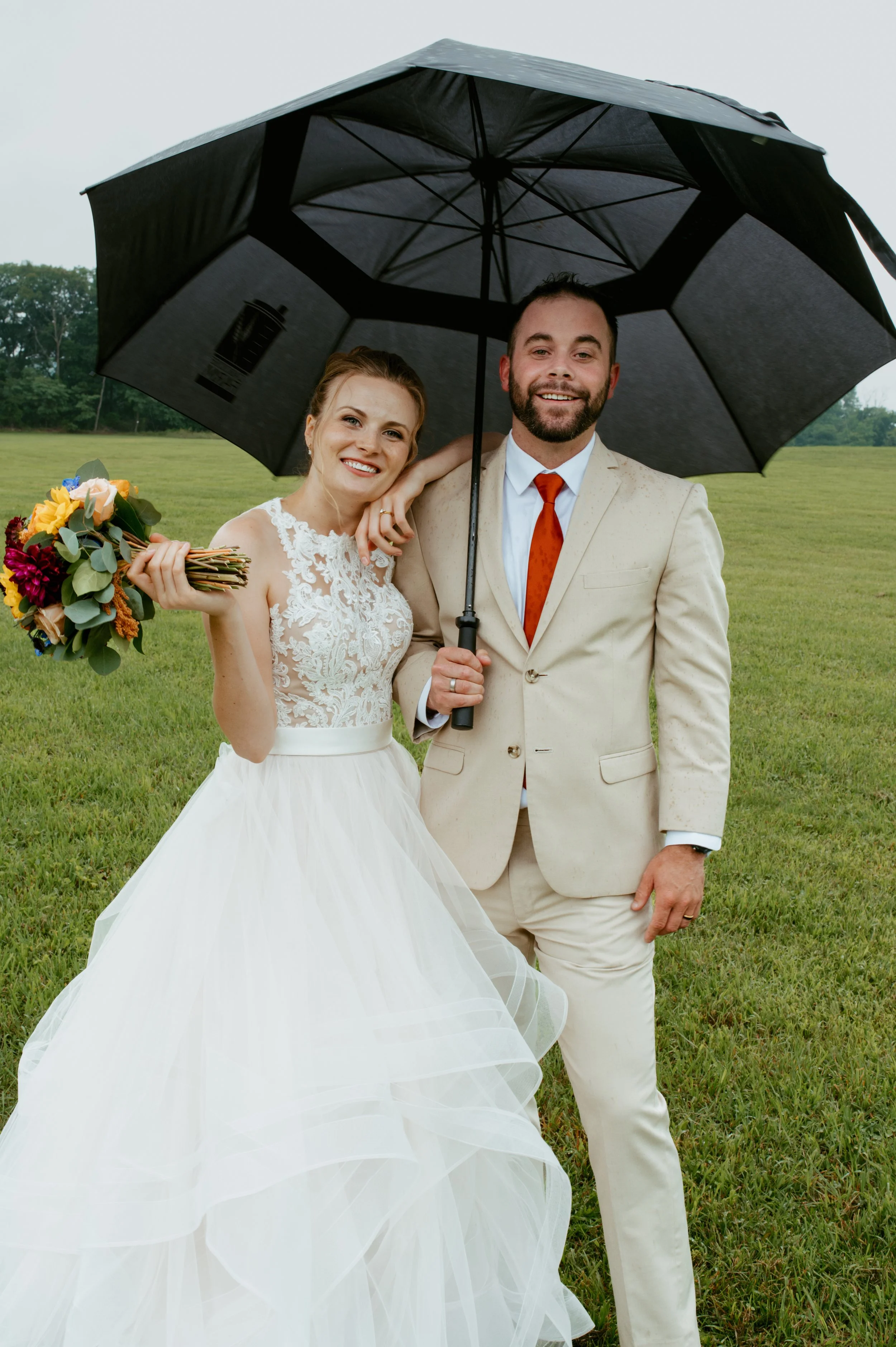 bride and groom under umbrella happy