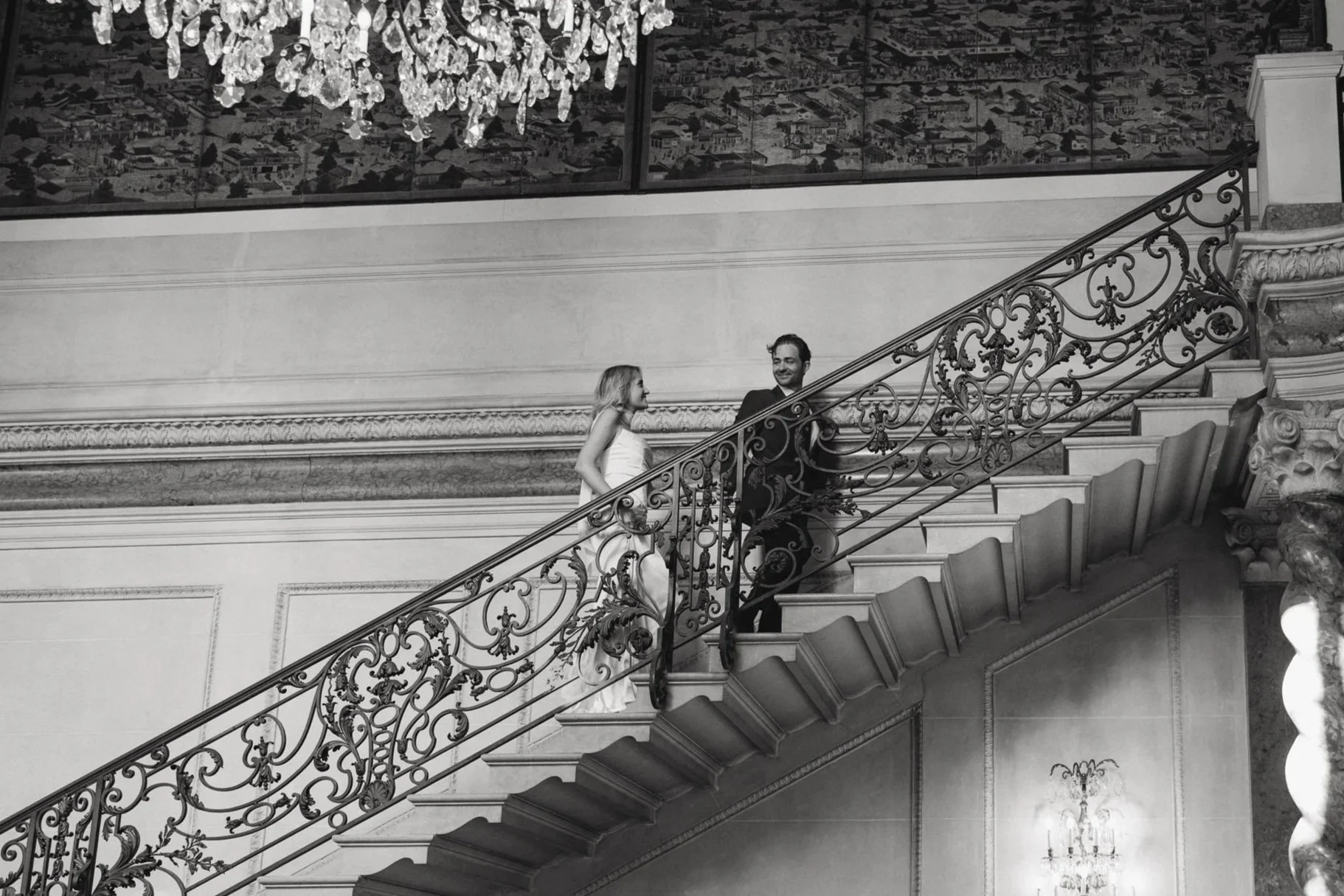 engaged couple walking up the staircase at the larz anderson house during their engagement photos
