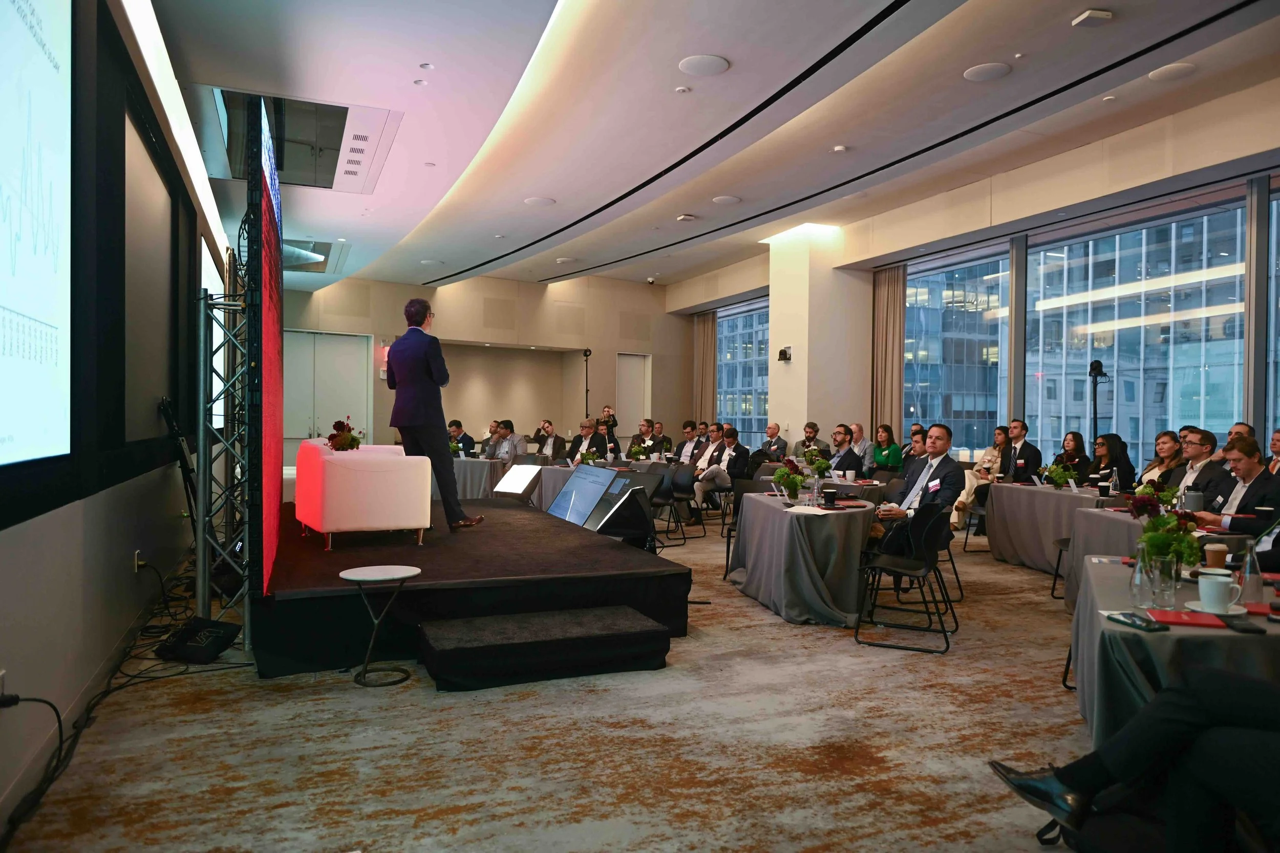 Wide view of attendees seated at tables during the Hines symposium