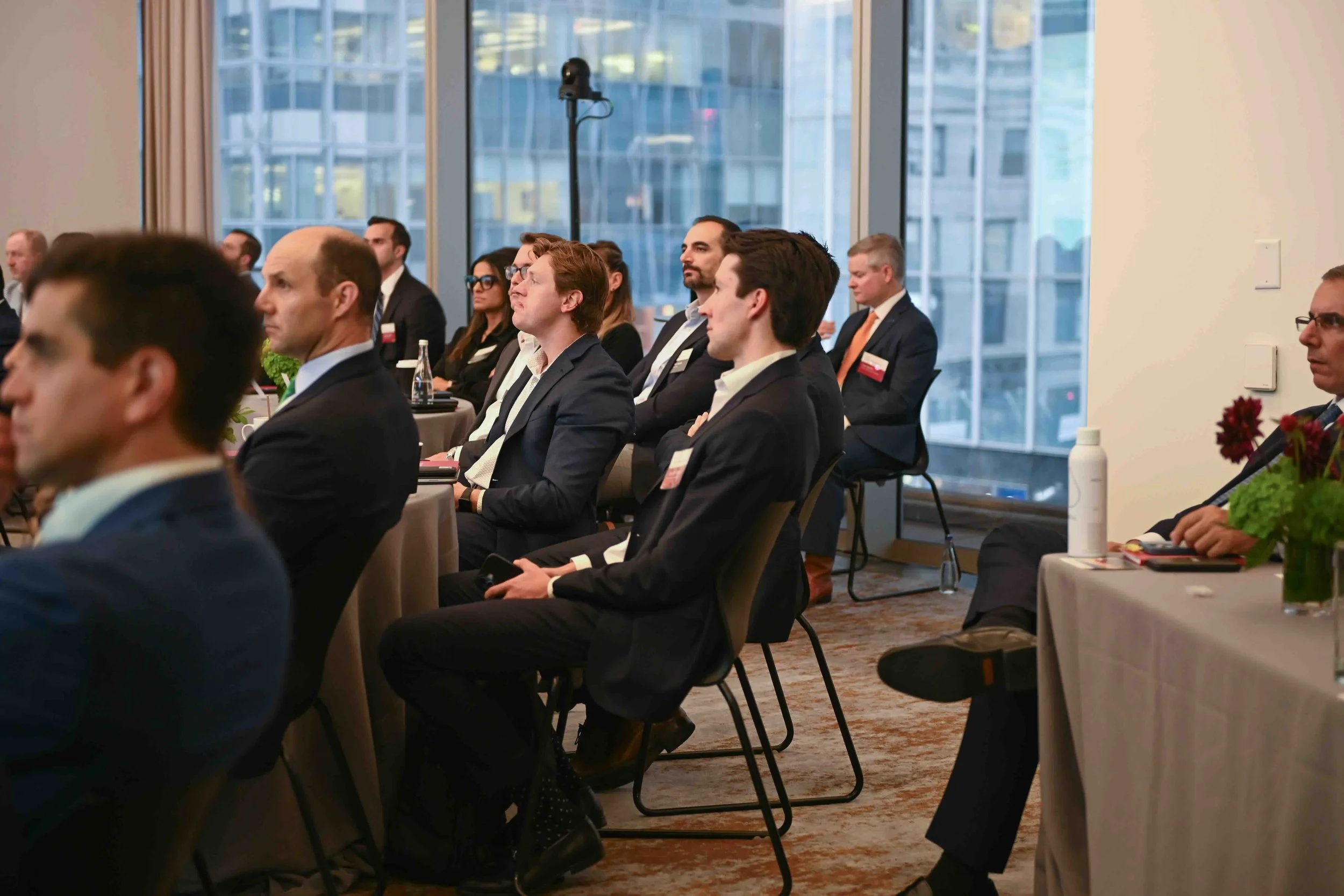Attendees in business attire seated and listening at the Hines symposium