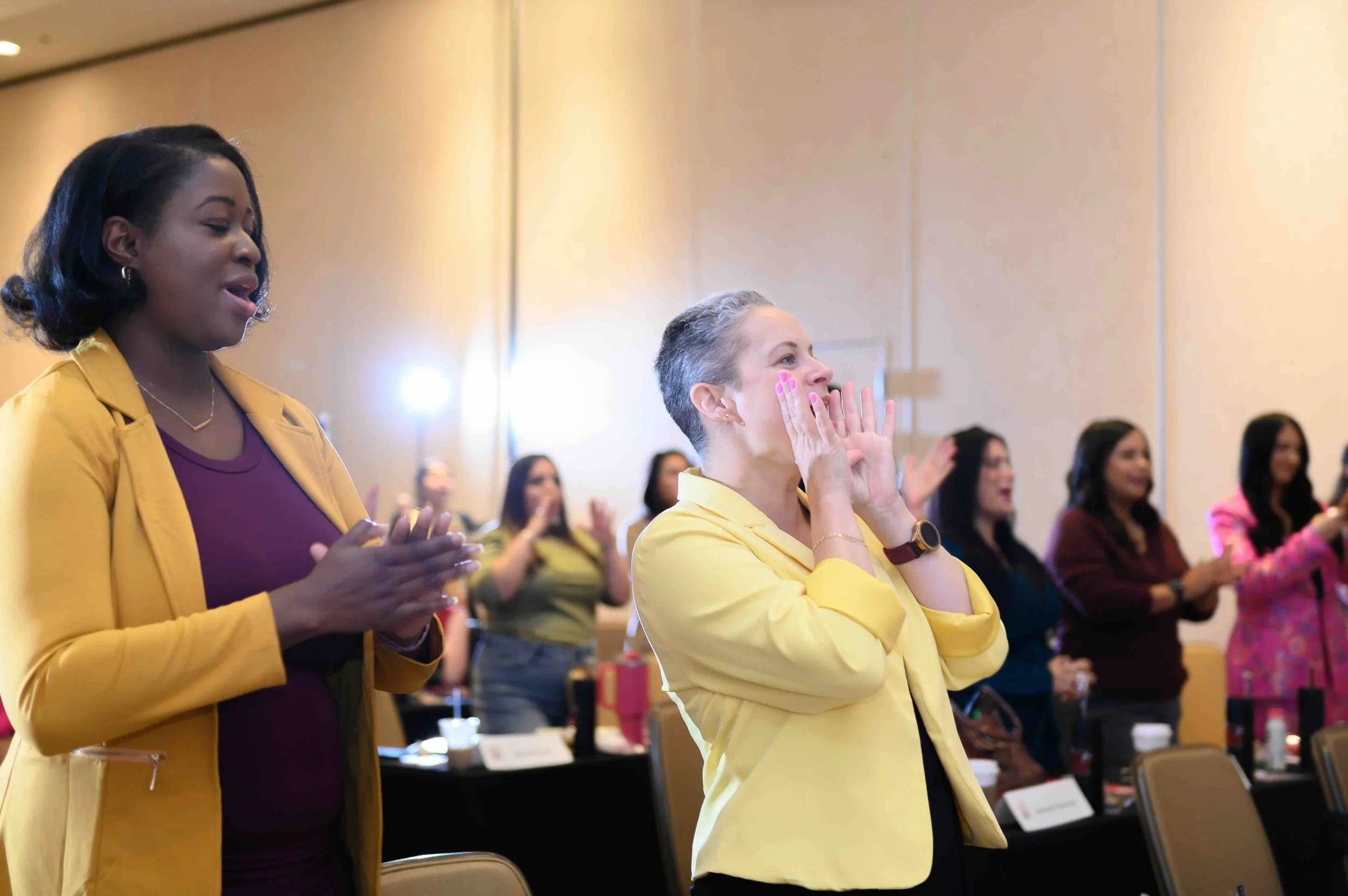 Attendees in colorful outfits gathered together in the ballroom