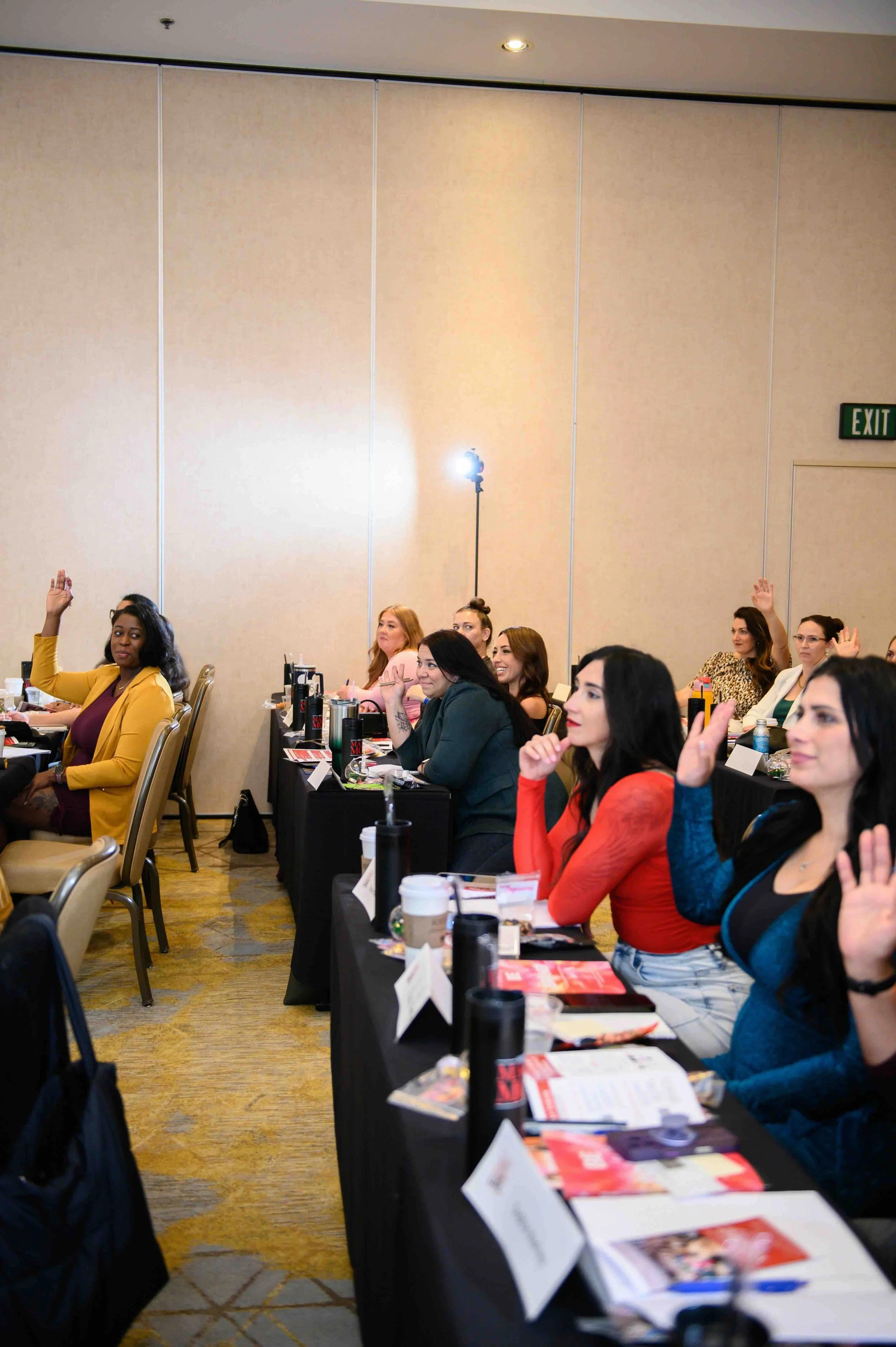 Attendees raising their hands during a session at She's Made For More