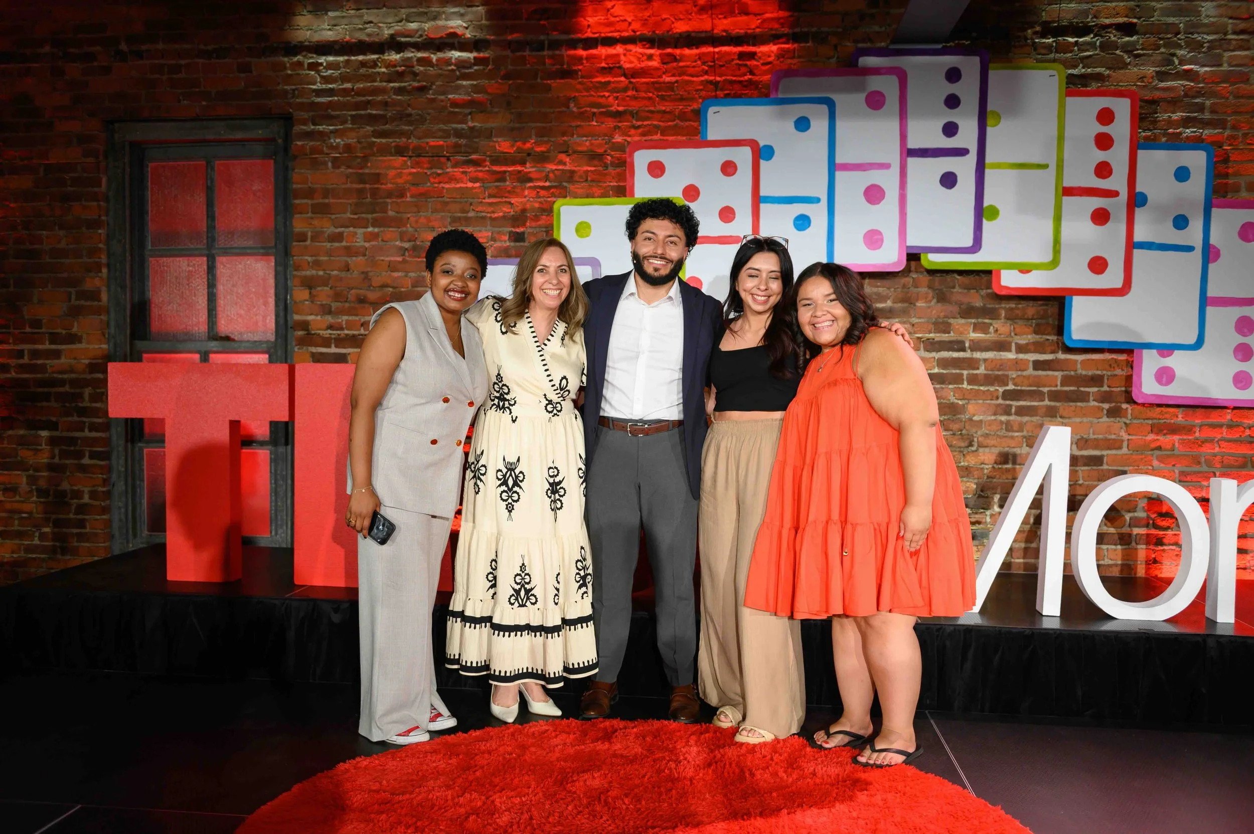 Group of TEDx Montclair speakers posing together on stage
