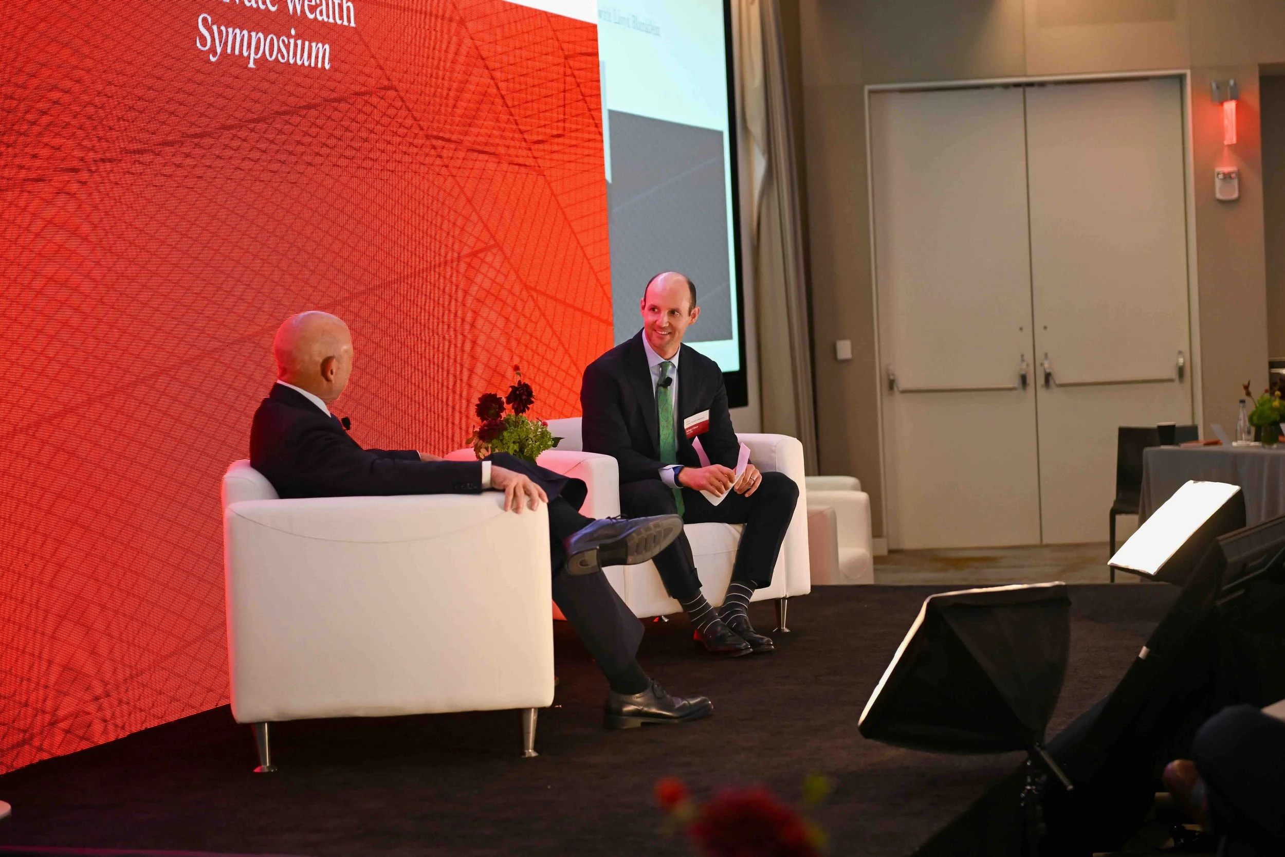 Two speakers seated on stage during a panel at the Hines symposium
