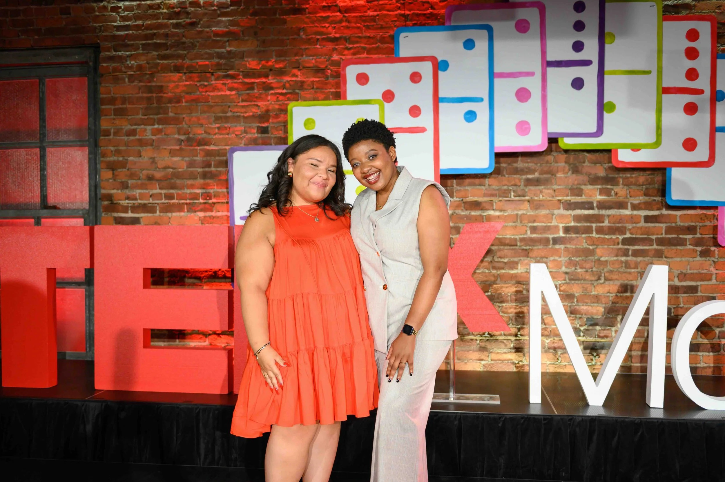 Two people posing together on the TEDx Montclair stage