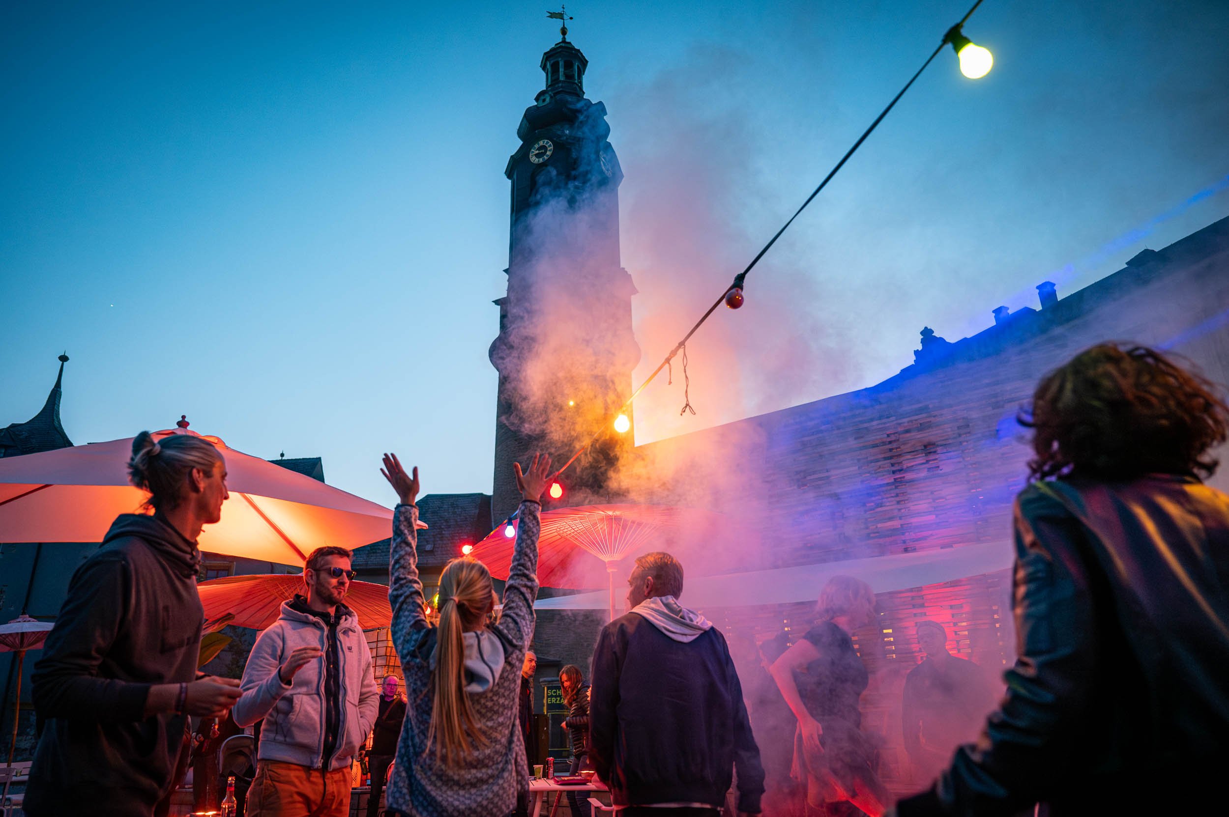 Menschen feiern abends im Freien vor dem beleuchteten Weimarer Stadtschloss. Veranstaltungsfotografie.