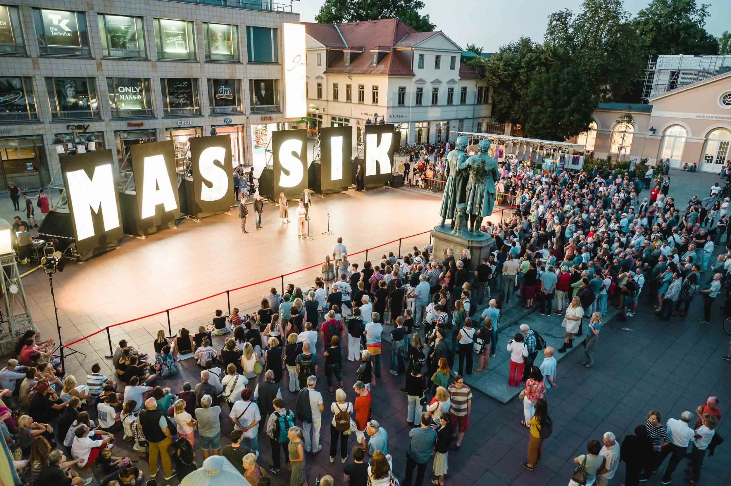 Große Menschenmenge beim Kunstfest Weimar auf dem Theaterplatz, im Hintergrund das Goethe-Schiller-Denkmal. Festivalfotografie.