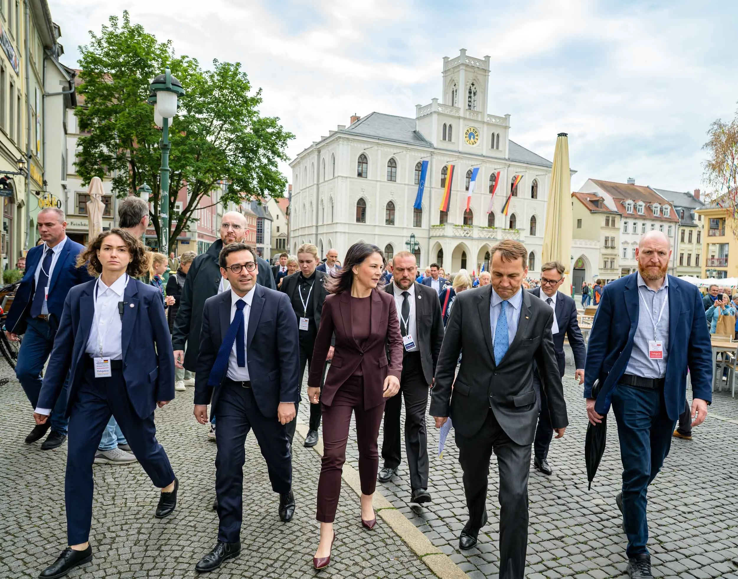 Delegation in Anzügen geht über den Weimarer Marktplatz vor dem Rathaus. Veranstaltungsfotografie.