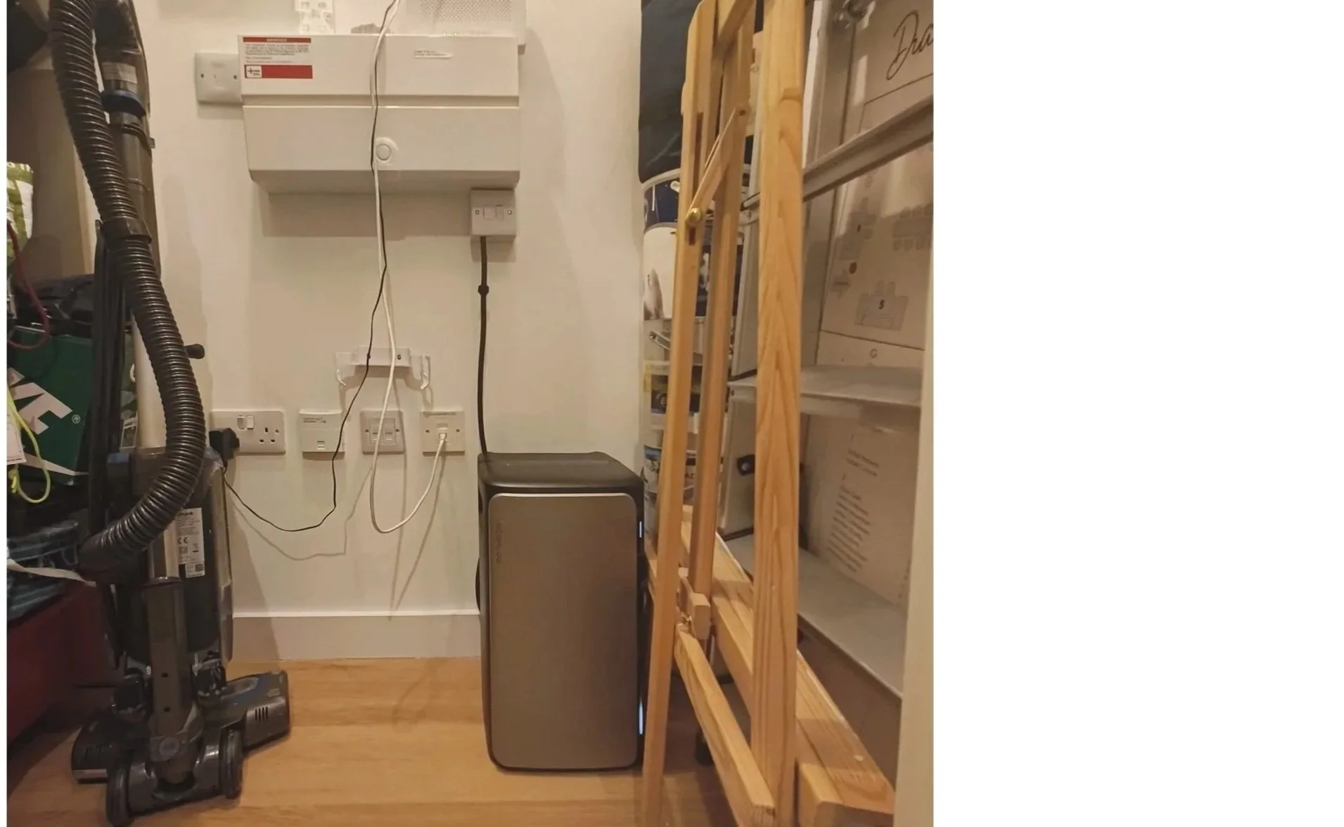plug-in battery installed neatly inside a modern flat utility cupboard near home appliances.