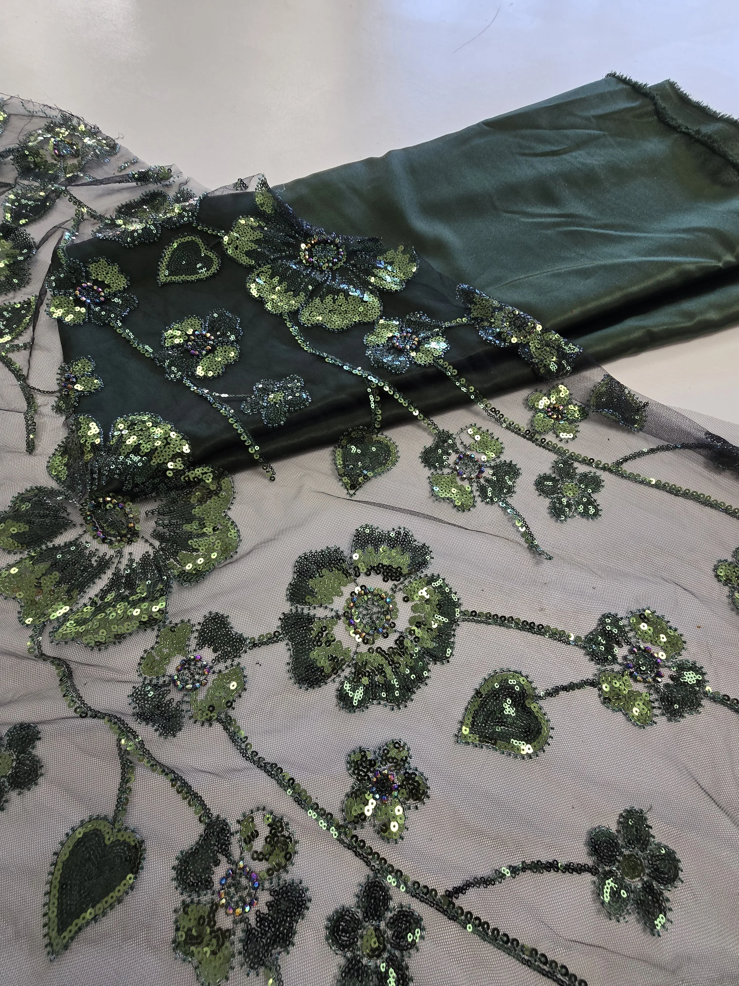 Sequin mesh fabric layered over emerald satin