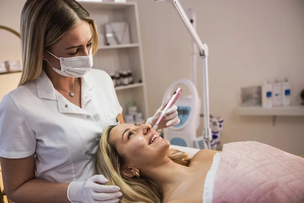 A woman receiving a cosmetic facial treatment from a medical professional in a clinic clean room.