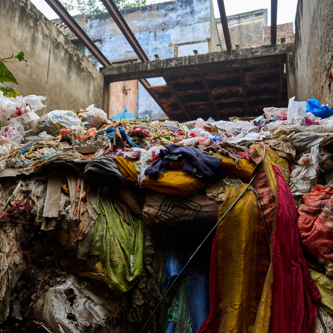 Pile of dirty, old textiles and other garbage outside