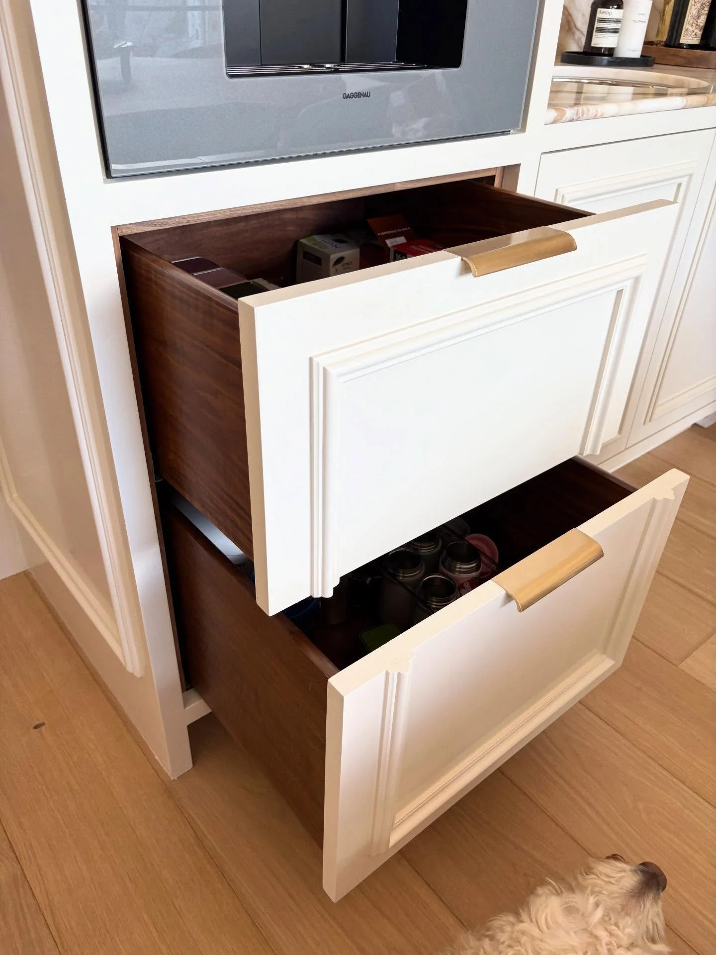 Paint Grade split-front cabinet fronts with stained solid Walnut 🌲 drawer boxes and mortised brass edge pulls for our Kitchen project in Pacific Palisades is finished and receiving final adjustments! 🙌🏼 ✨