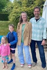 A mom, dad, and two daughters seated in a park, enjoying a family adventure and quality time outdoors during a custom scavenger hunt