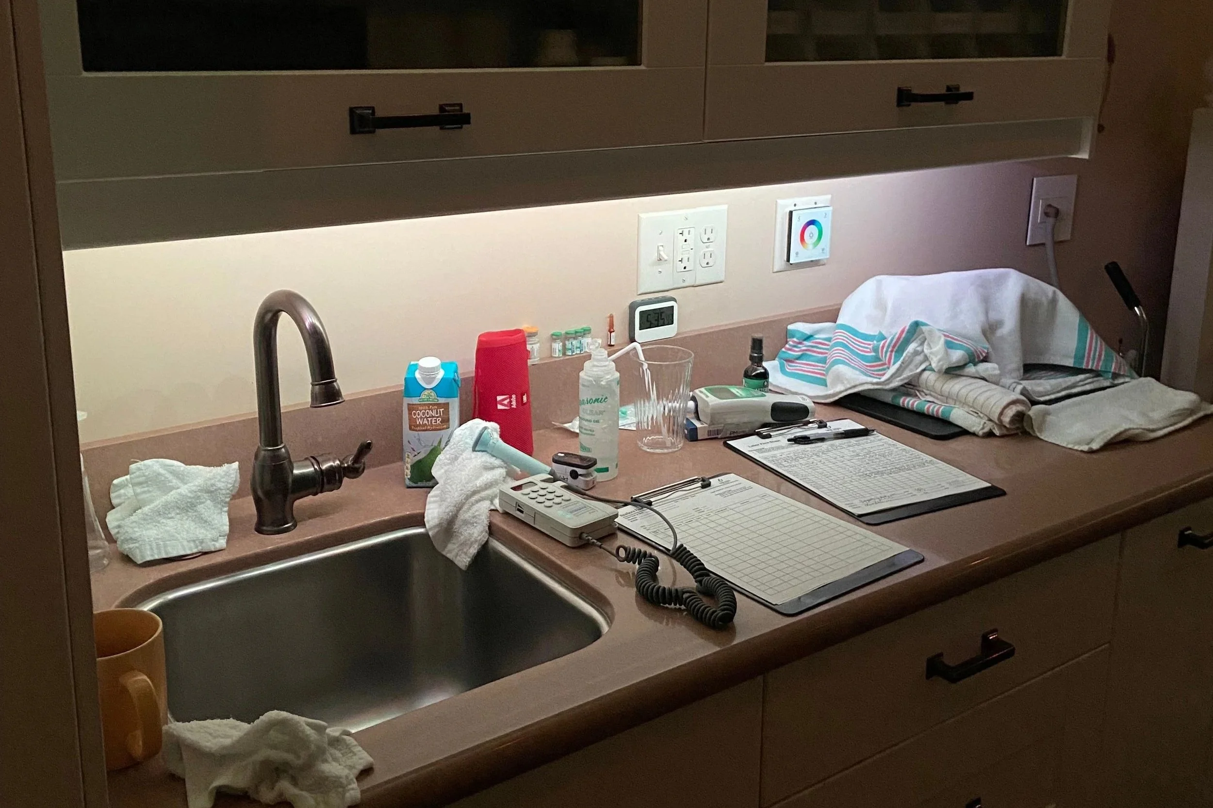 labor room counter with paper charts, fetal doppler, baby blanket, speaker, snacks