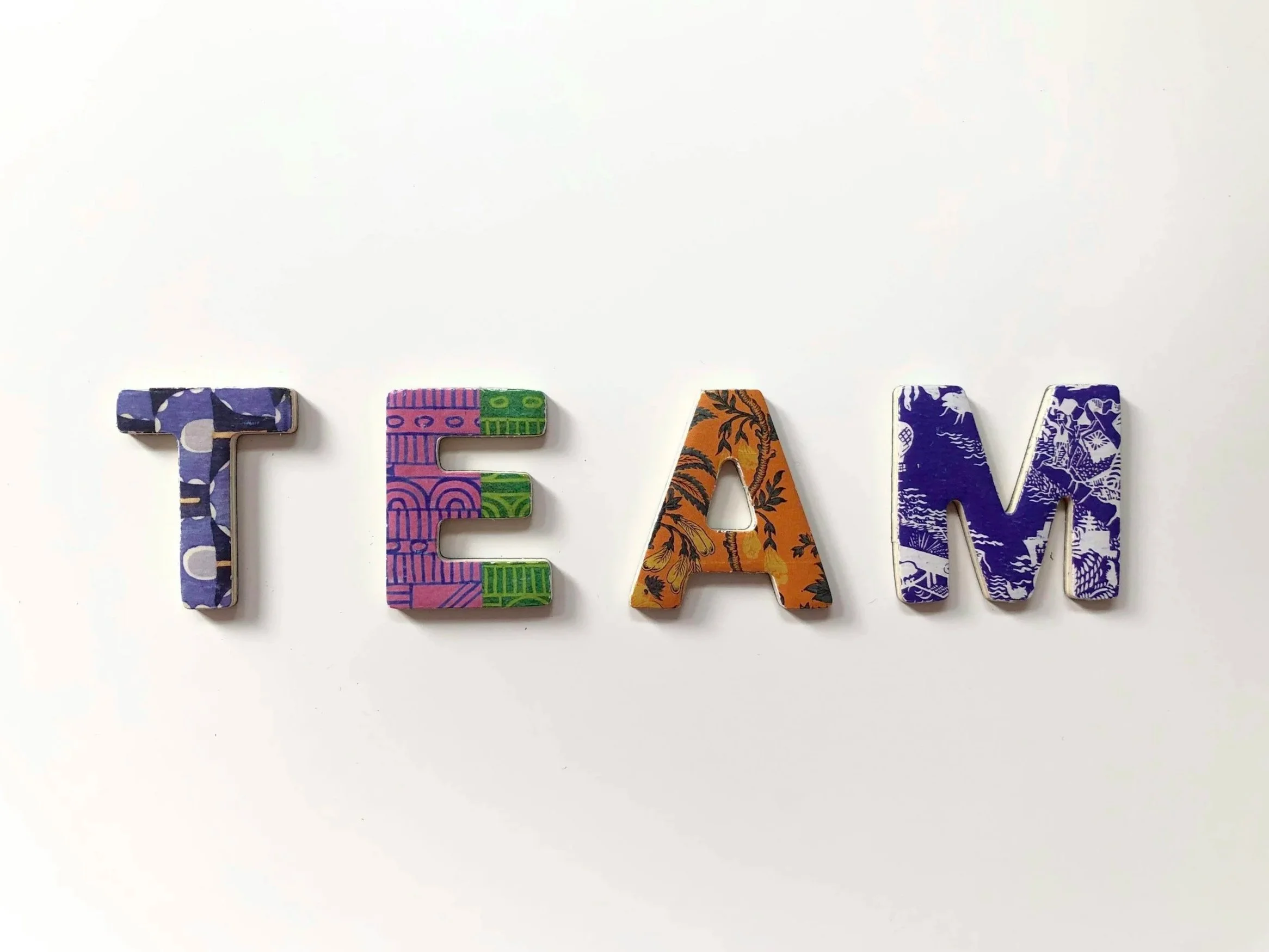 Colorful decorative letters spelling 'TEAM' on a white background.