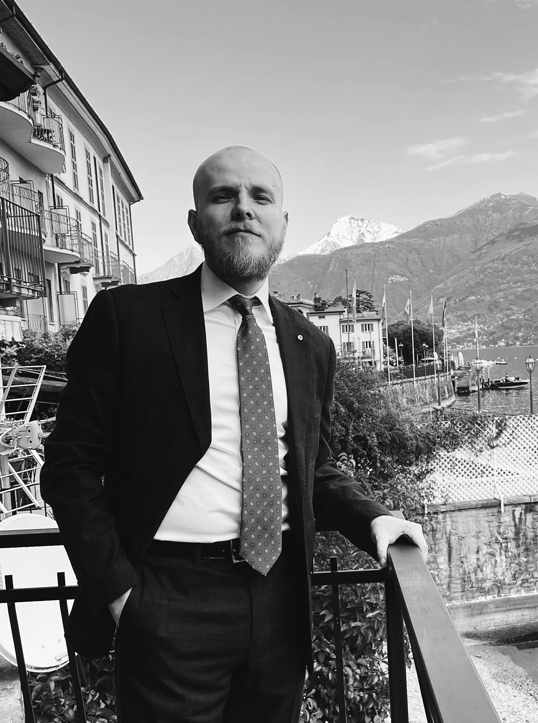 Kuvassa juristi Alexandre Eisman puku päällä. Taustalla vuoristoa ja järvimaisema. Mustavalkoinen kuva.