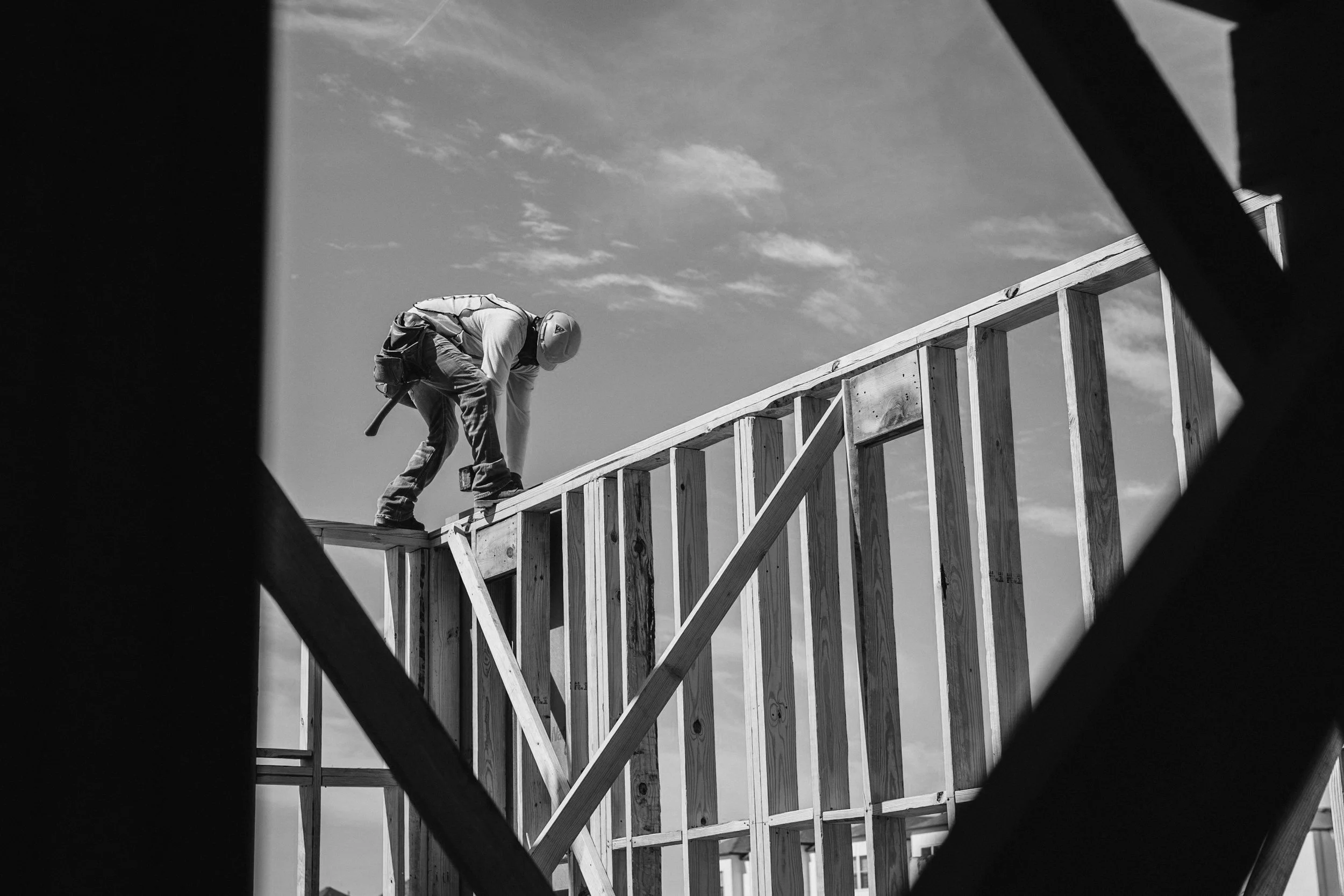 Construction worker building wooden frame structure on site